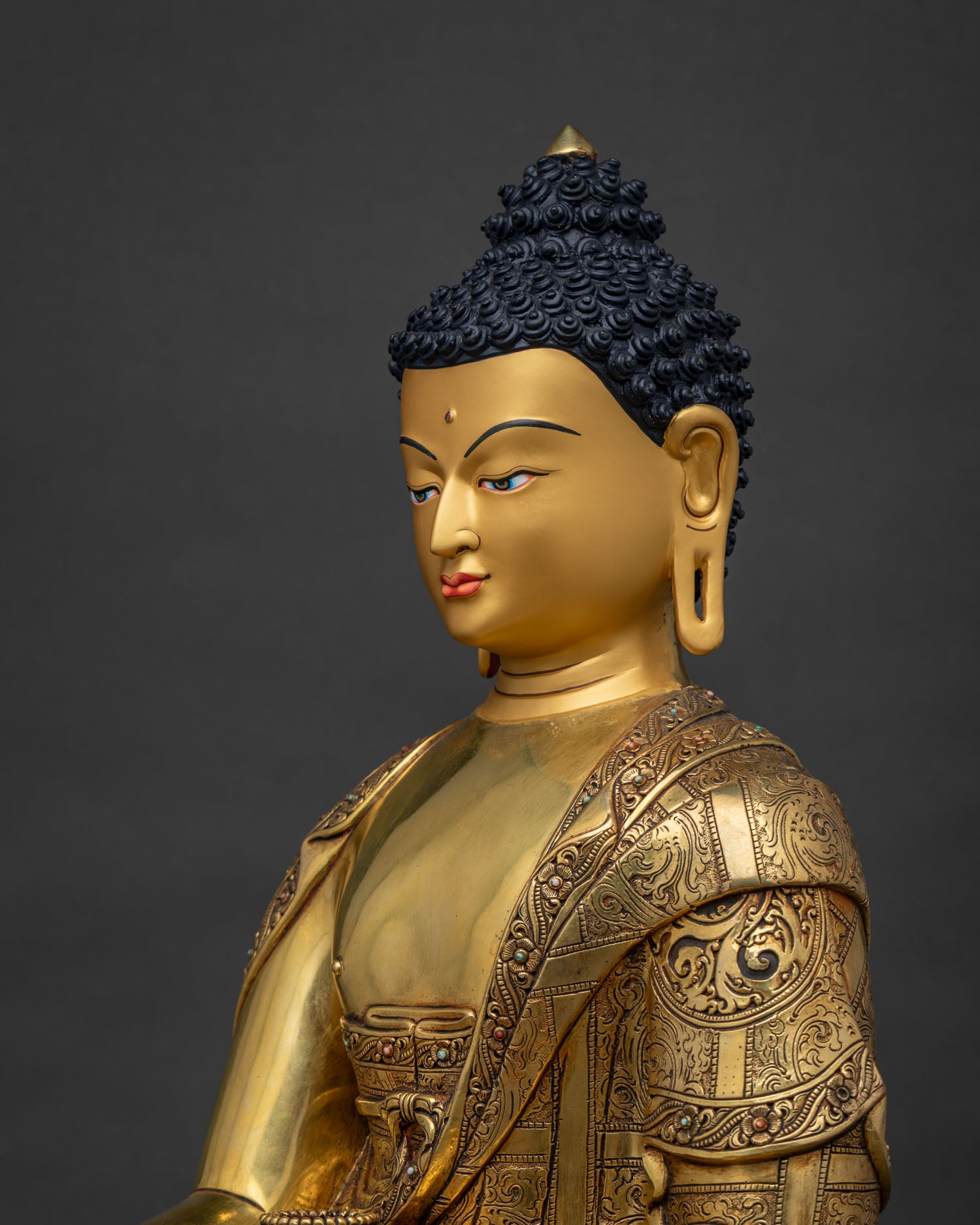 Side close up of Shakyamuni Buddha statue showing hand carved copper robe