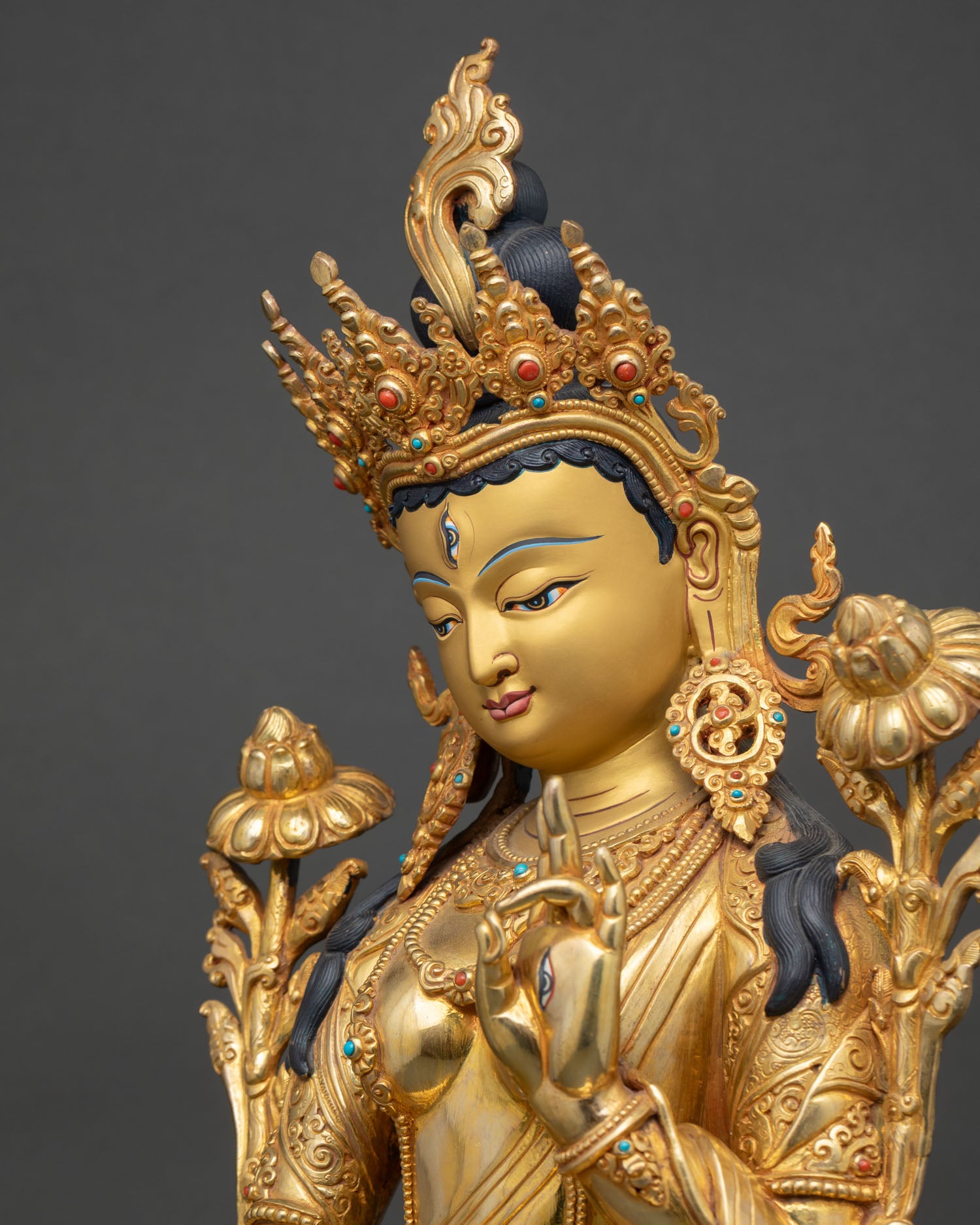 side close-up of white tara buddhist statue with utpala flower and carved ornaments