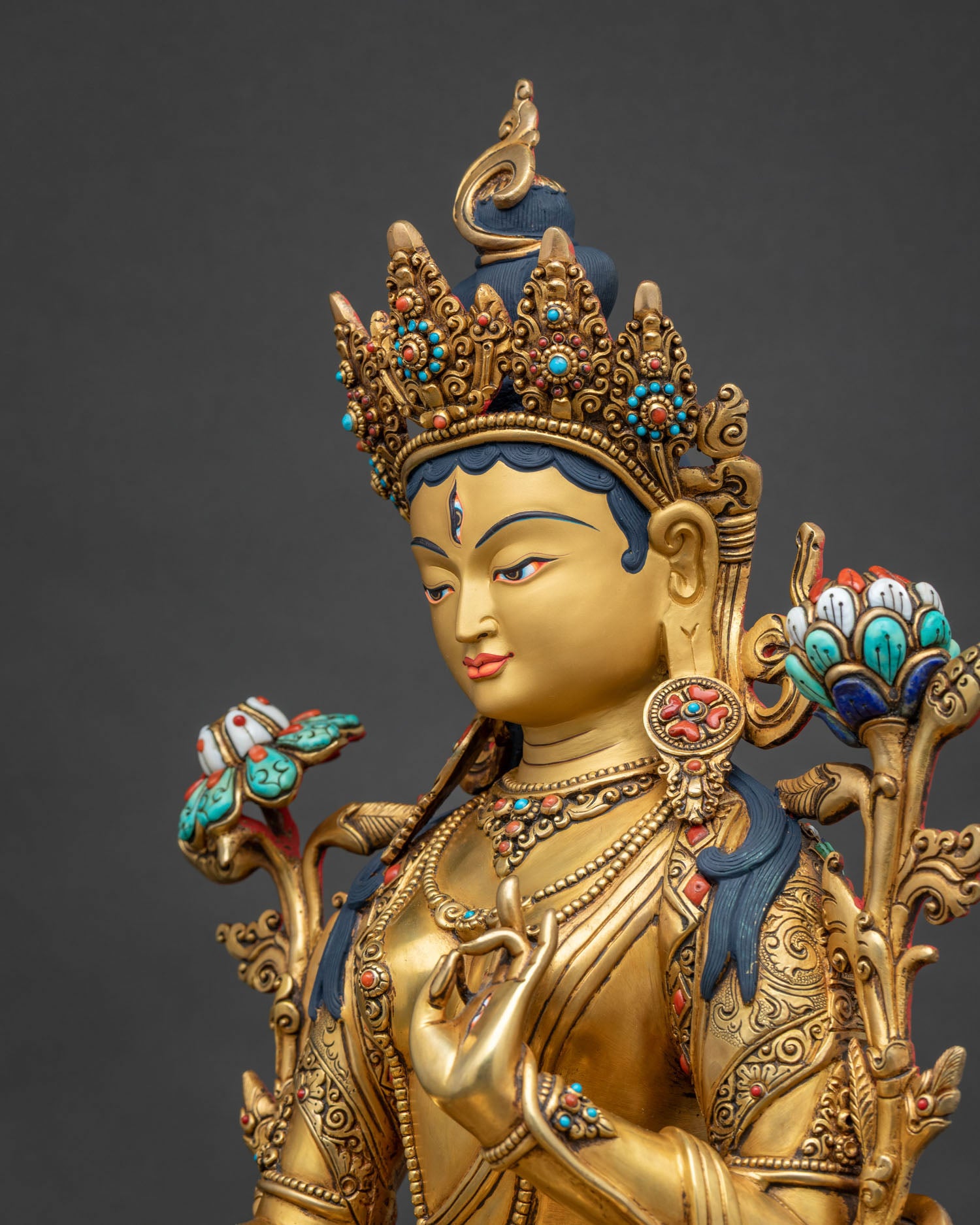 Side close-up of White Tara statue showing crown and lotus flower detail