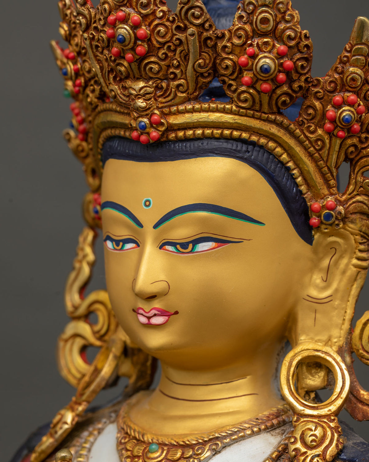 Side close-up of Vajrasattva's face showing gold paint and crown ornamentation
