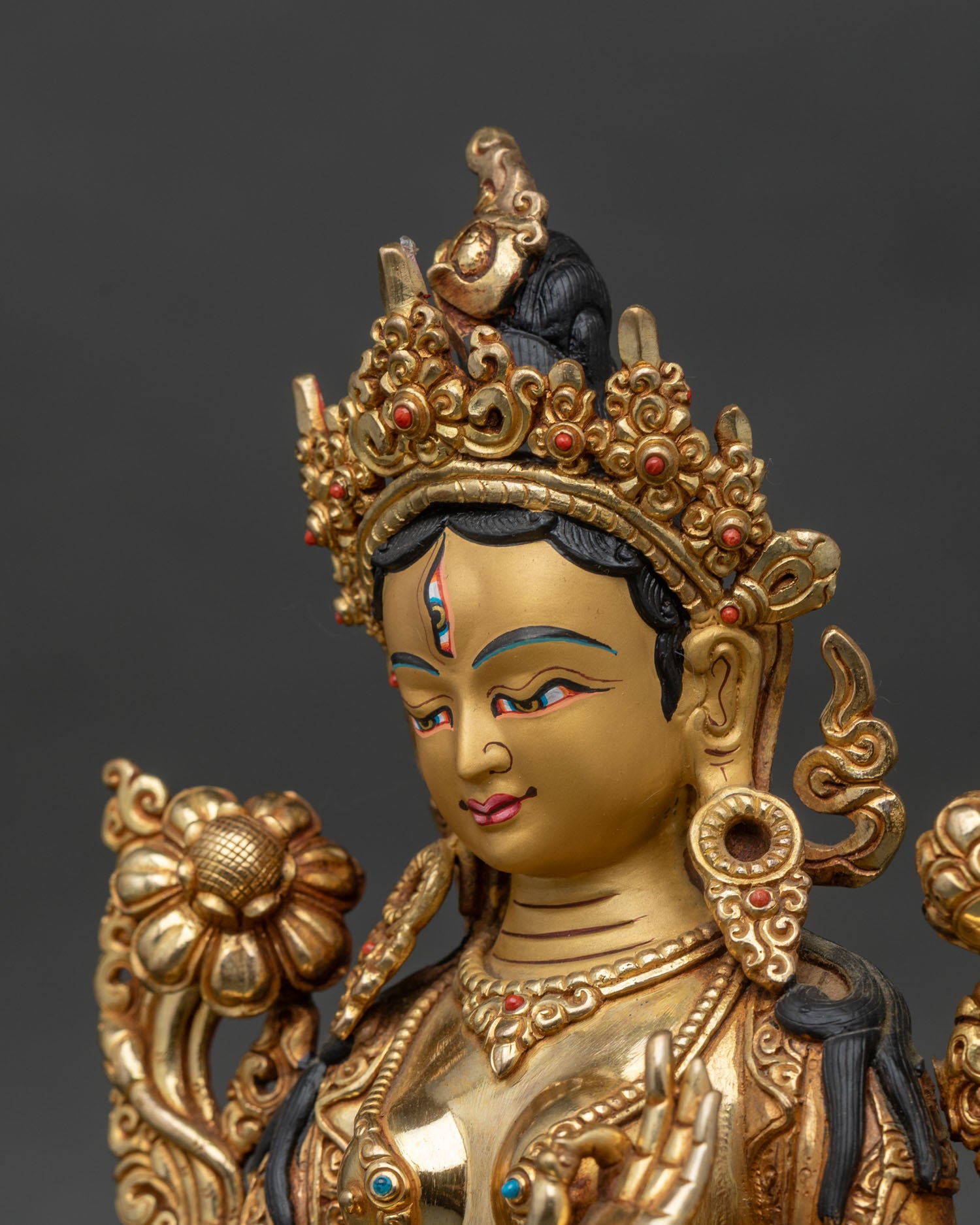 Side close-up of White Tara statue, ornate lotus seat and flaming halo visible