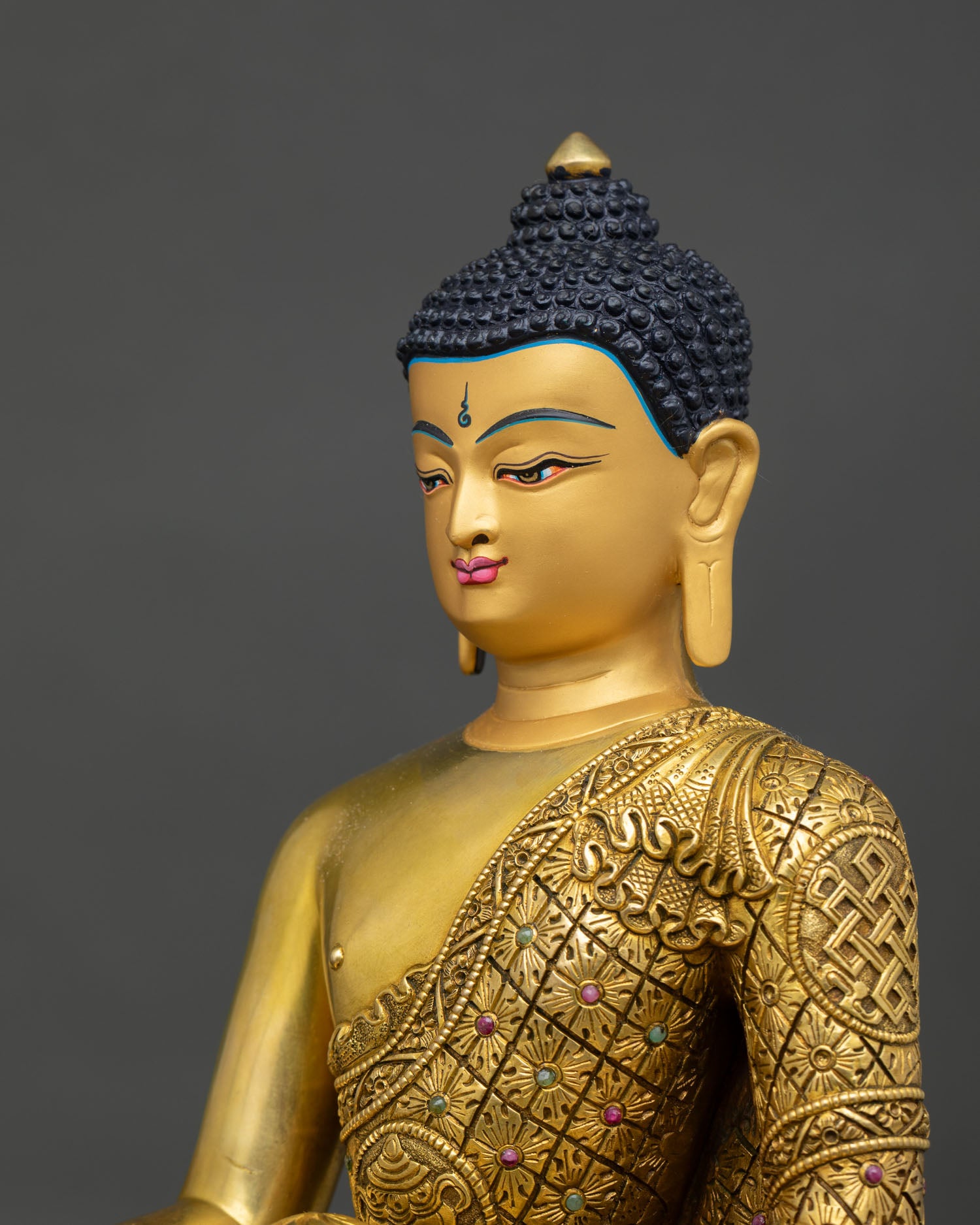 Side detail of Shakyamuni Buddha statue showing intricate robe carving and repoussé artwork