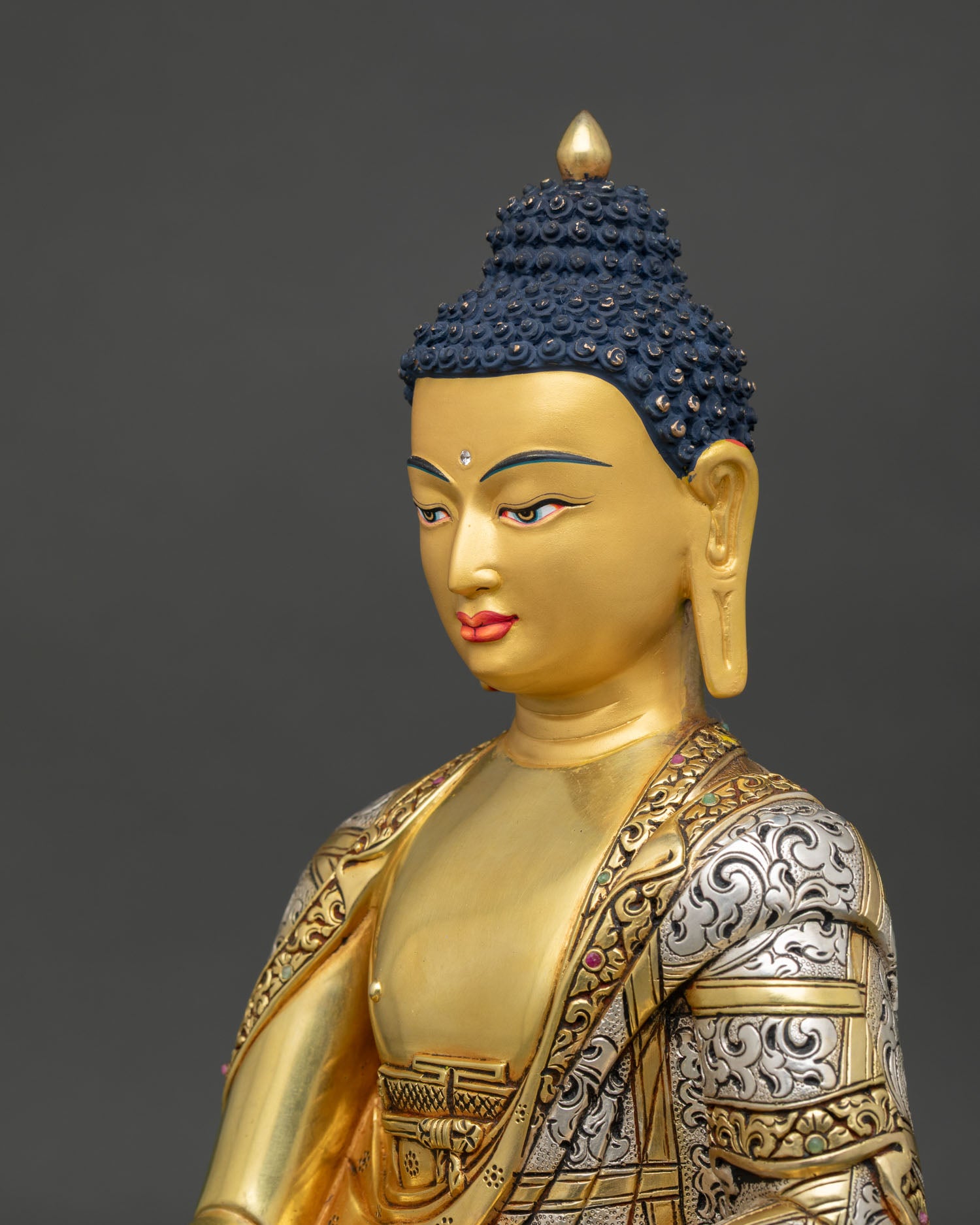 Side detail of Shakyamuni Buddha statue showing ornate monk robe patterns