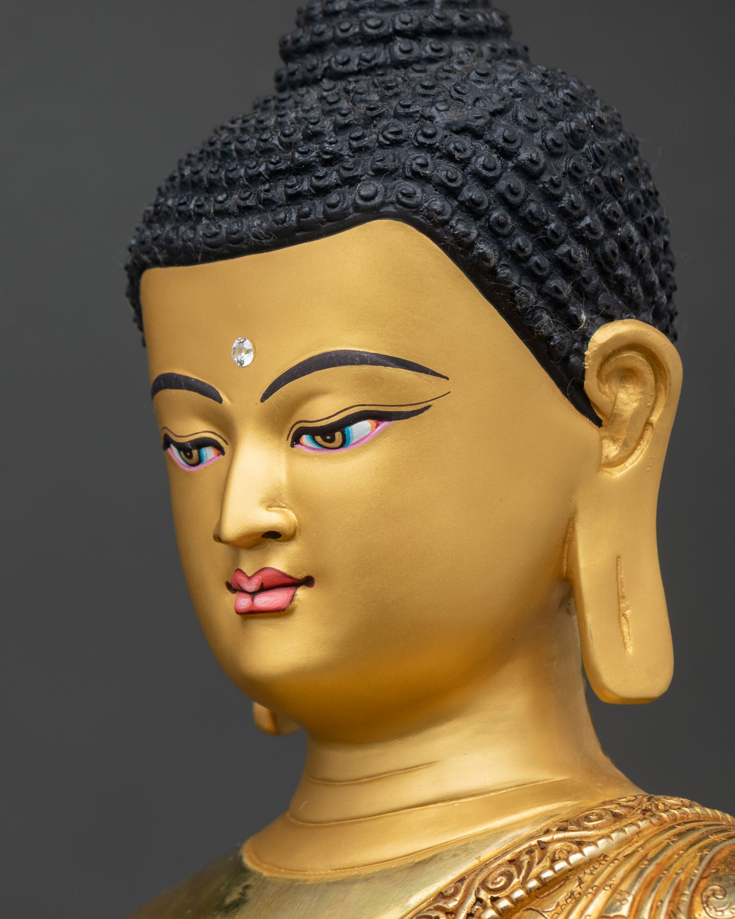 side face close up shakyamuni buddha serene gold face intricate repoussé buddhist sculpture