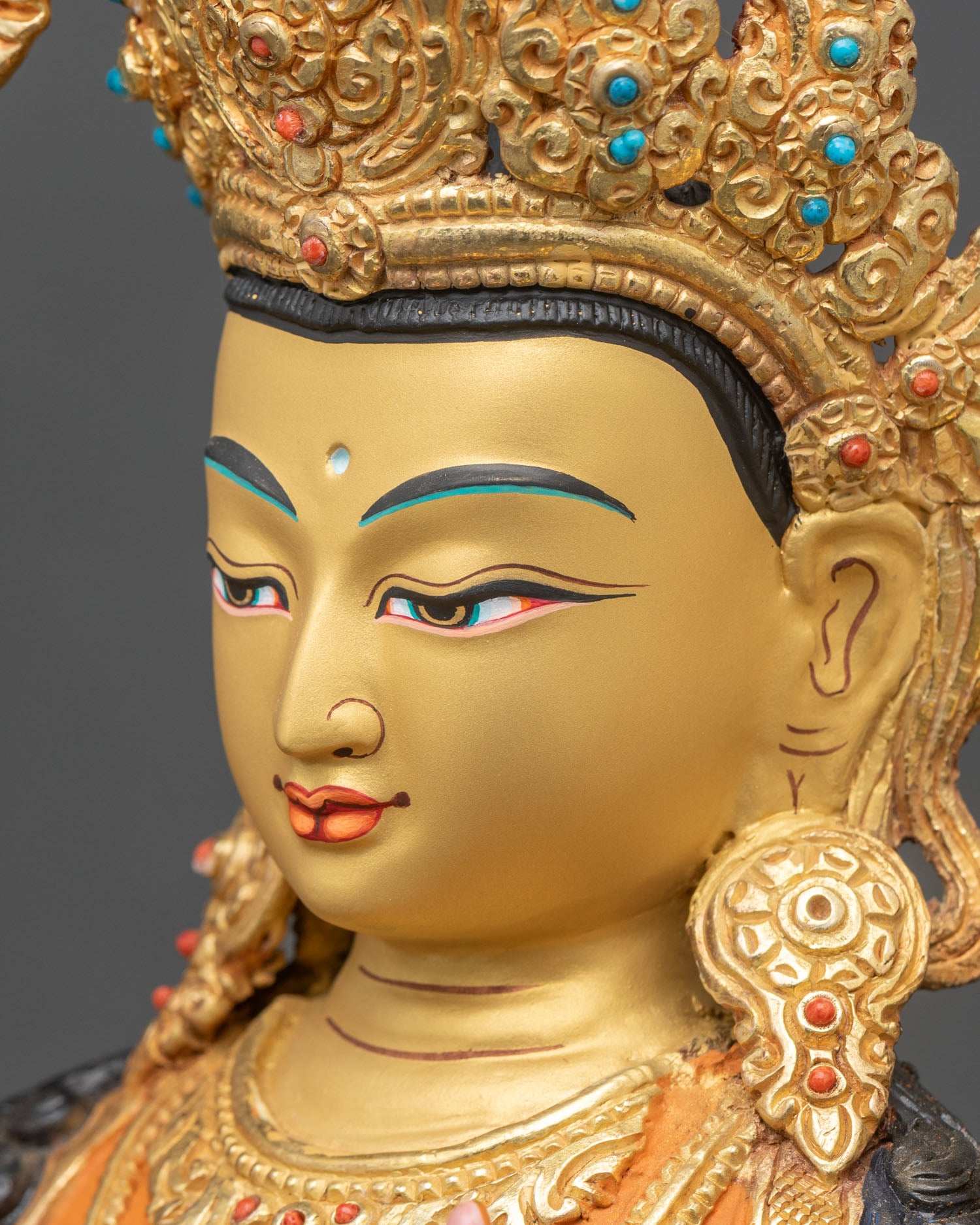 Side face detail of Manjushri with golden features and intricate ornamentation