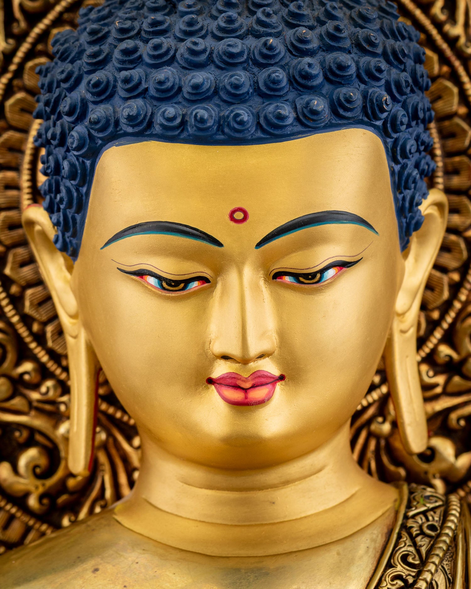 Side profile close‑up of Amitabha Buddha statue face with gentle expression and intricate halo carvings