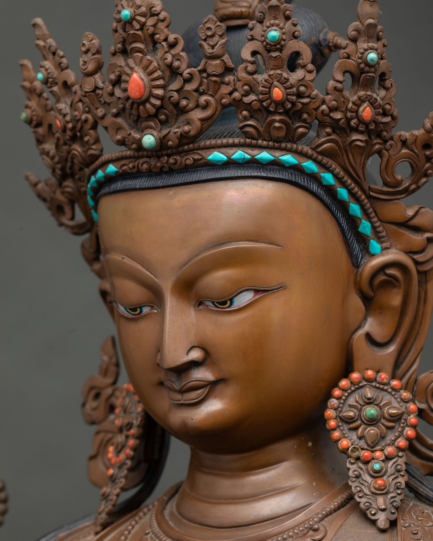 Side profile close-up of Chenrezig's face showing serene expression and crown detail