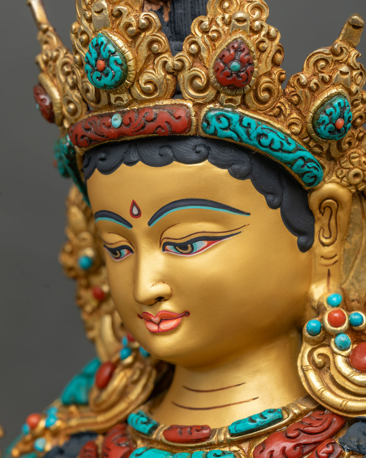 Side profile close up of Green Tara statue face and crown, handcrafted Newari gold gilded art