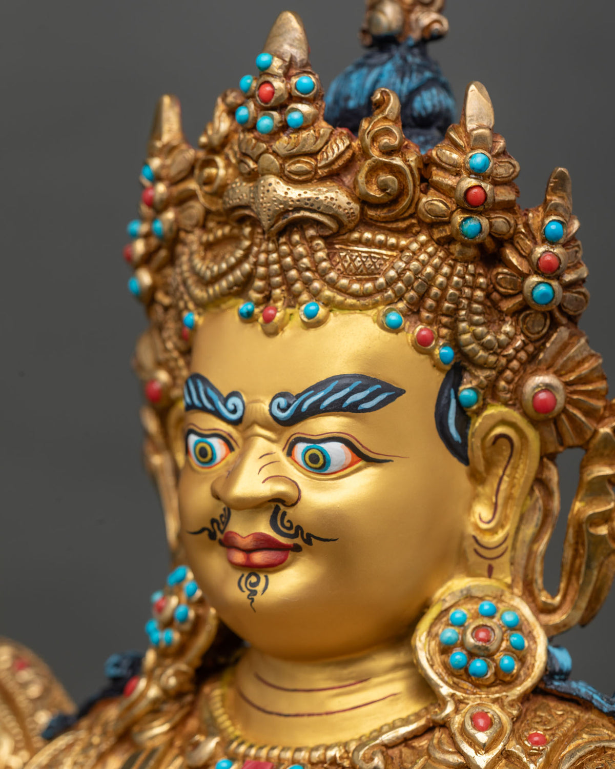 Side profile close-up of Namtoshe statue face with gold fire-gilding and jeweled crown