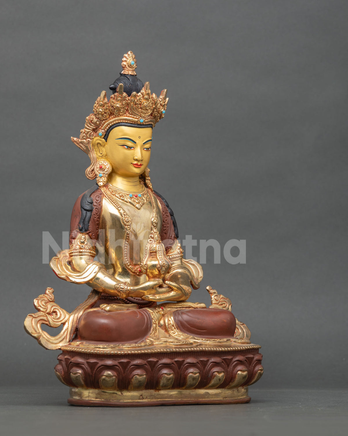 Side profile of handmade Tibetan Amitayus Buddha statue with gilded face and crown
