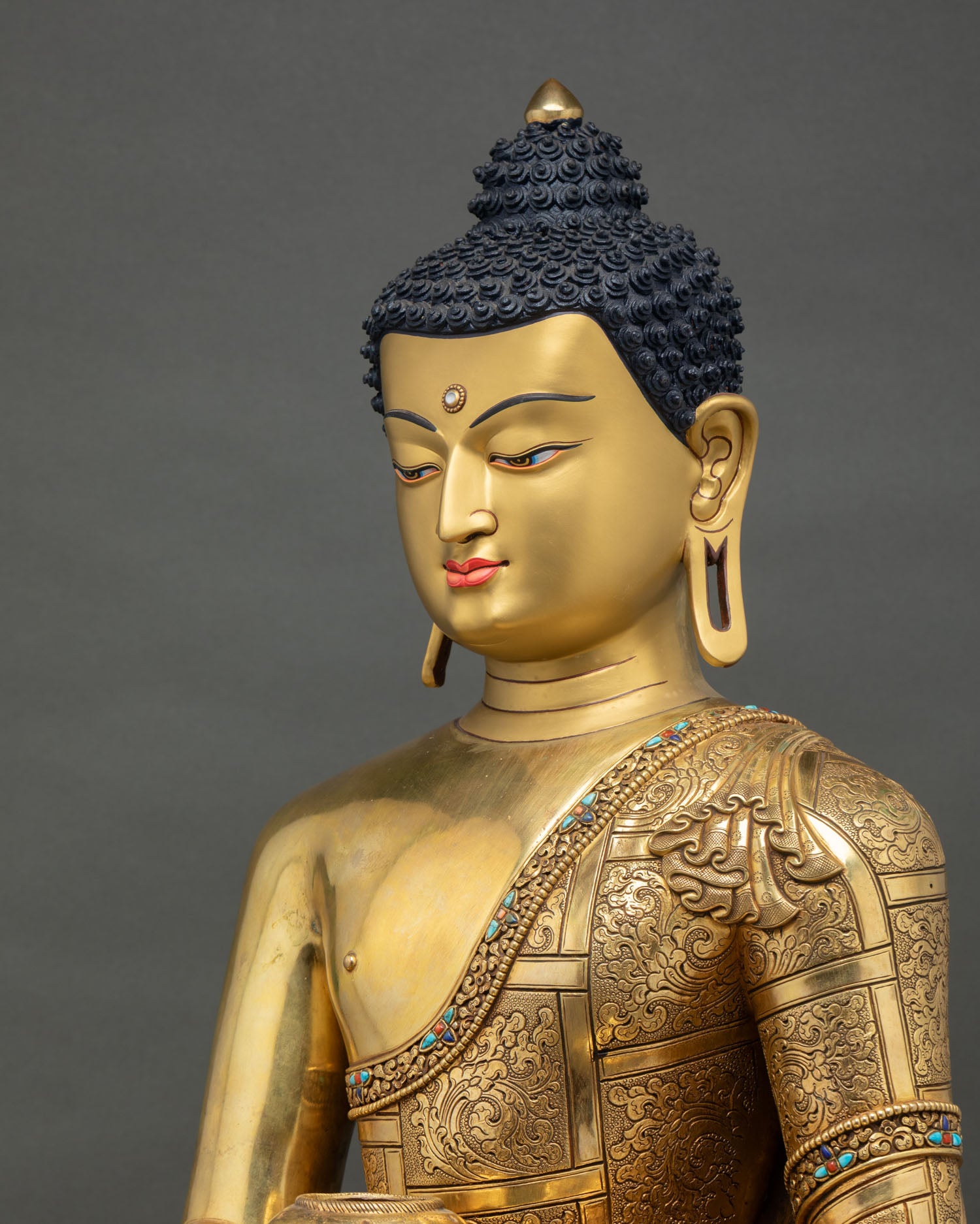 side profile of shakyamuni buddha statue showing ornate robe details