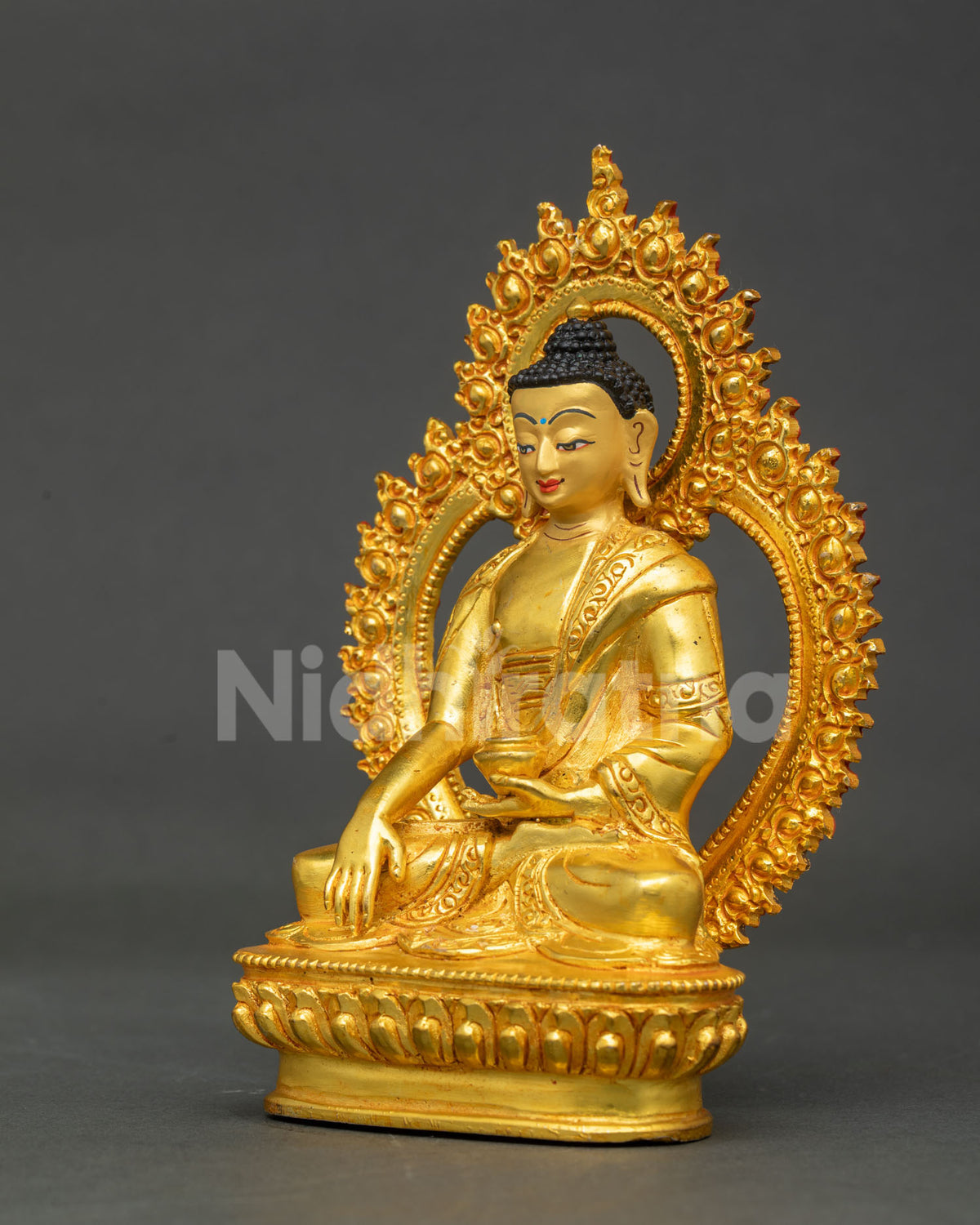 Side profile of Shakyamuni Buddha statue with ornate flame halo and floral robe details