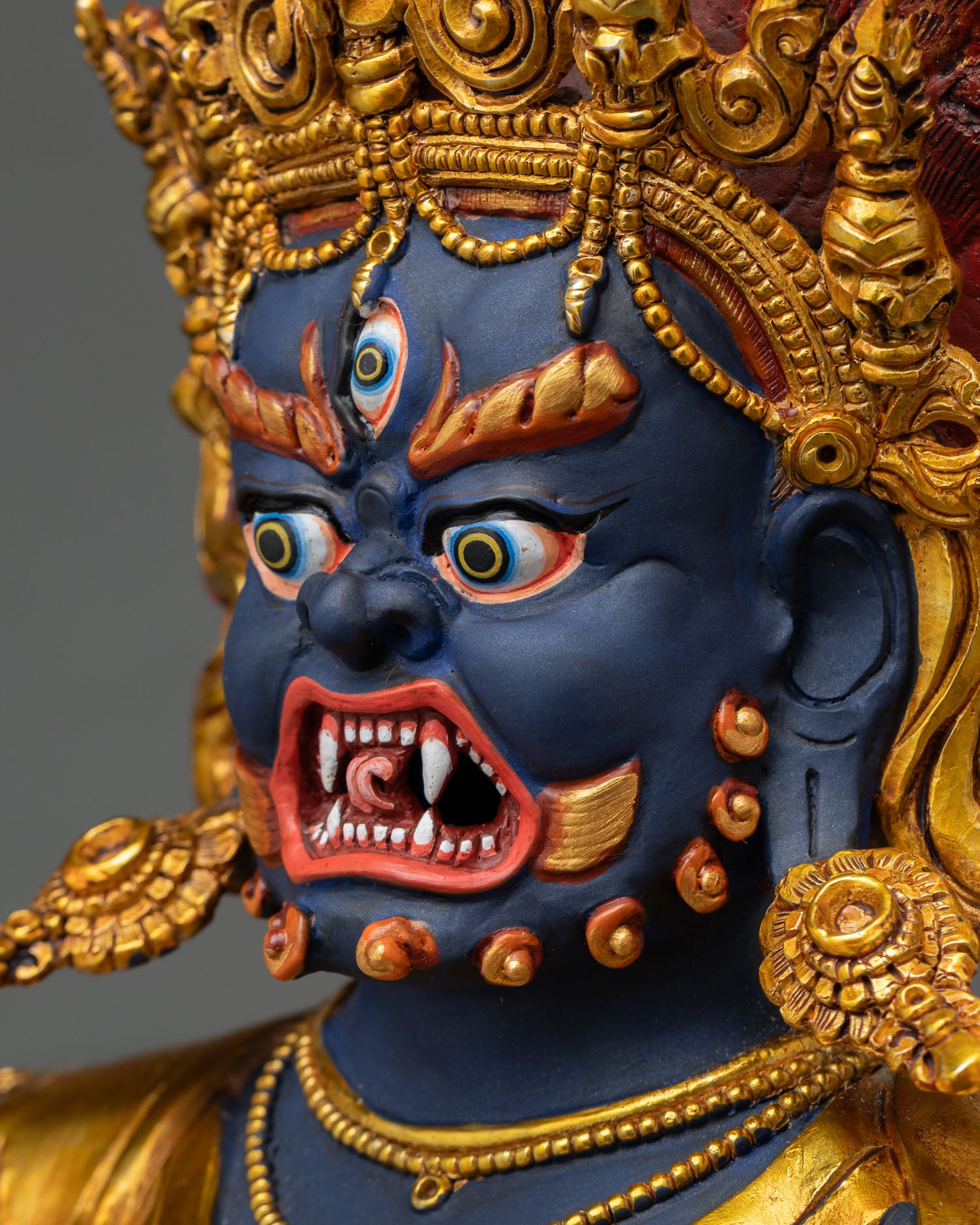 Side profile of Troma Nagmo Statue showcasing intricate crown and wrathful expression.