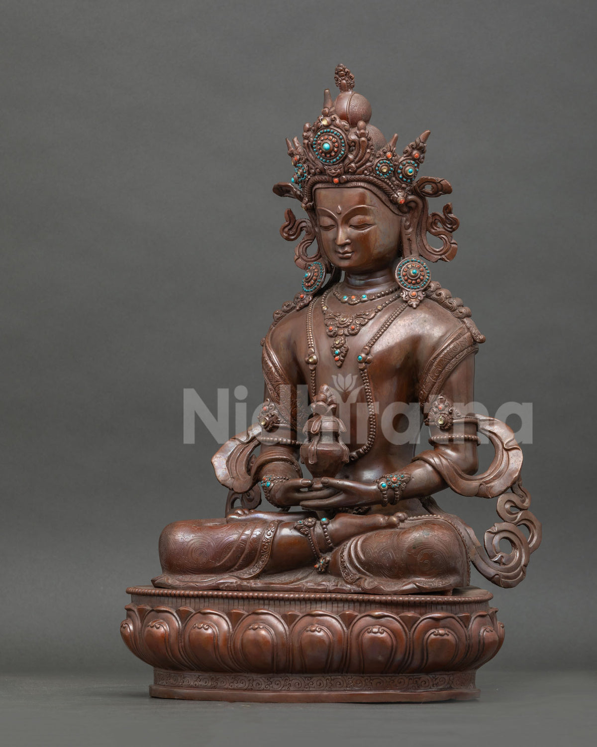 Side view Amitayus statue with intricate copper details lotus pedestal and oxidized finish.