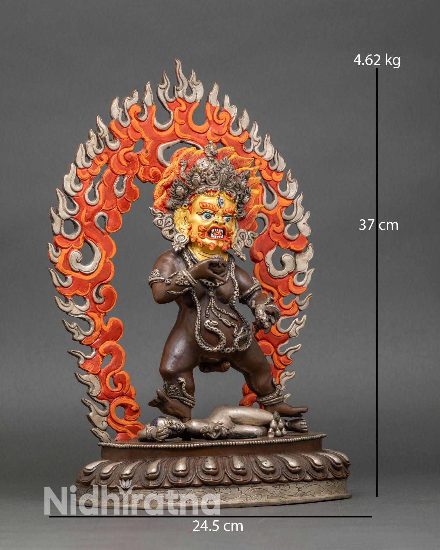 Side view of Black Dzambhala statue dynamic posture silver plated robes Himalayan craftsmanship