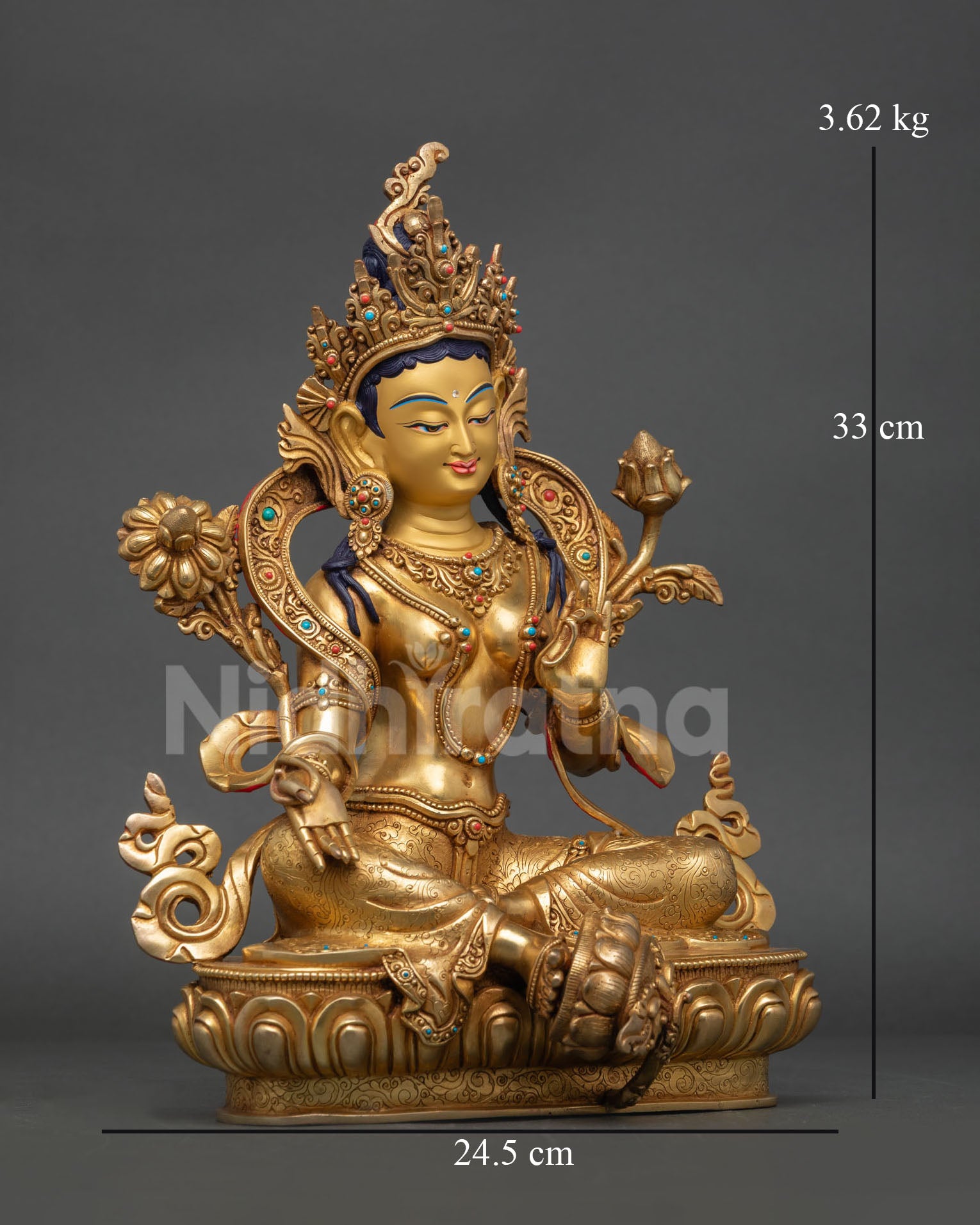 Side view of Green Tara statue, seated posture with extended right leg on lotus flower flowing royal garments