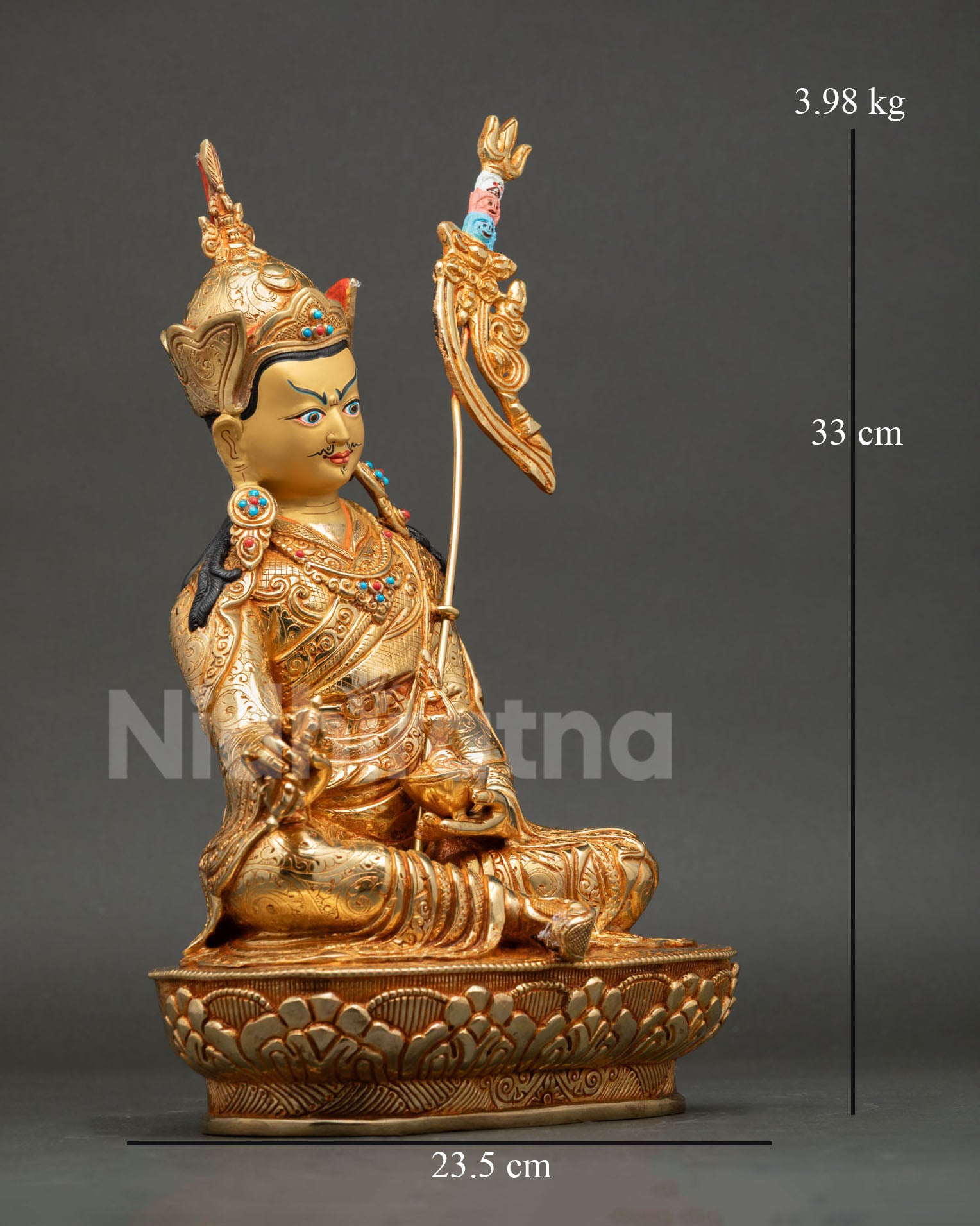 Side view of Guru Rinpoche seated on lotus pedestal holding vajra and skull cup, Tibetan Vajrayana meditation statue Nepal