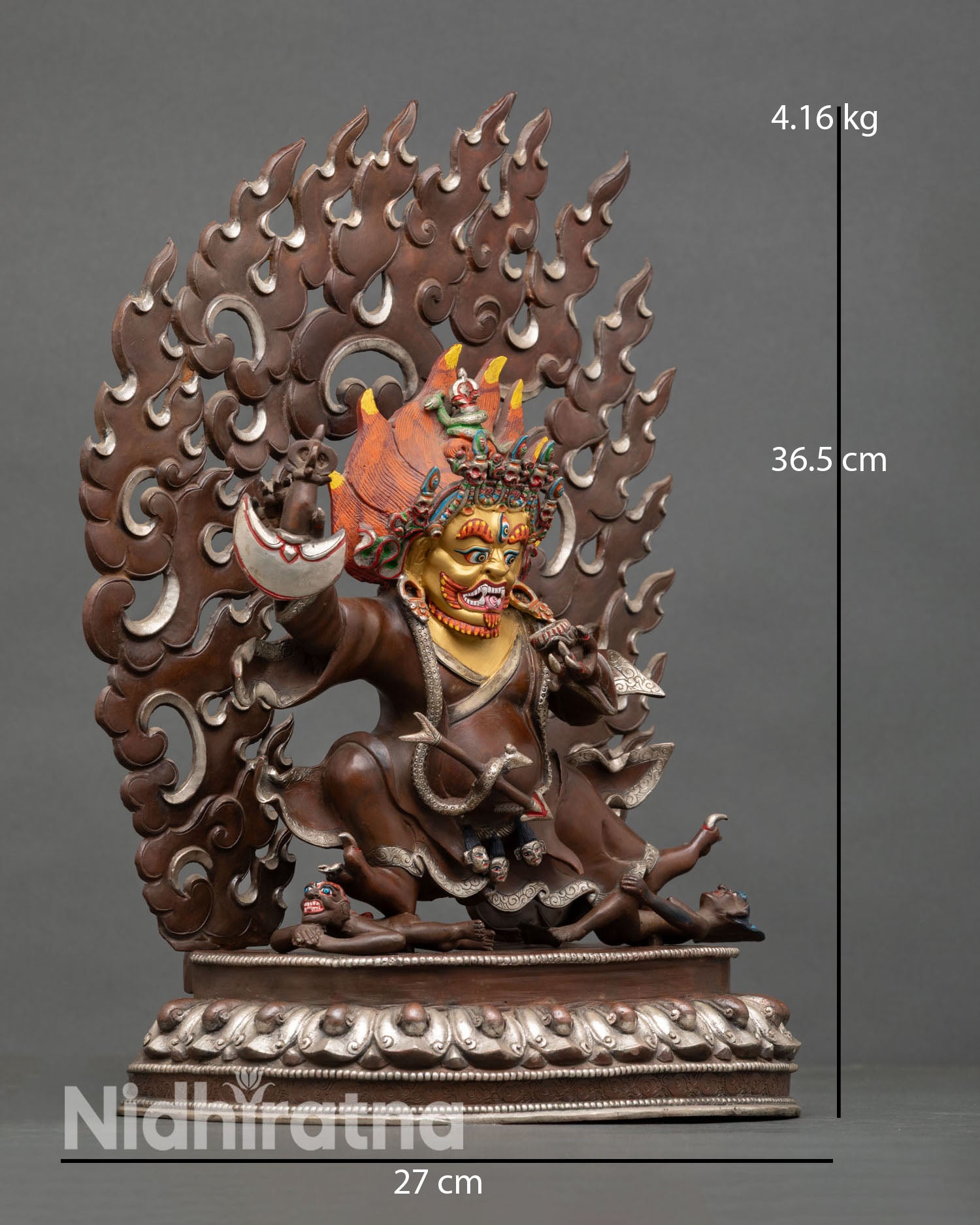 Side view of Mahakala Bernagchen statue lotus pedestal subdued figures sacred Buddhist guardian deity oxidized copper Himalayan craftsmanship