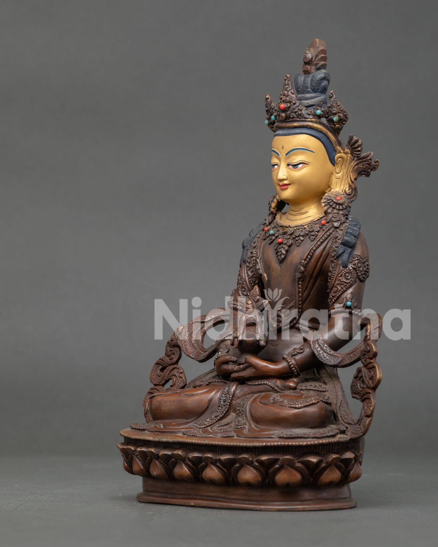 Side view of Amitayus statue seated on lotus throne holding the sacred ambrosia vase.