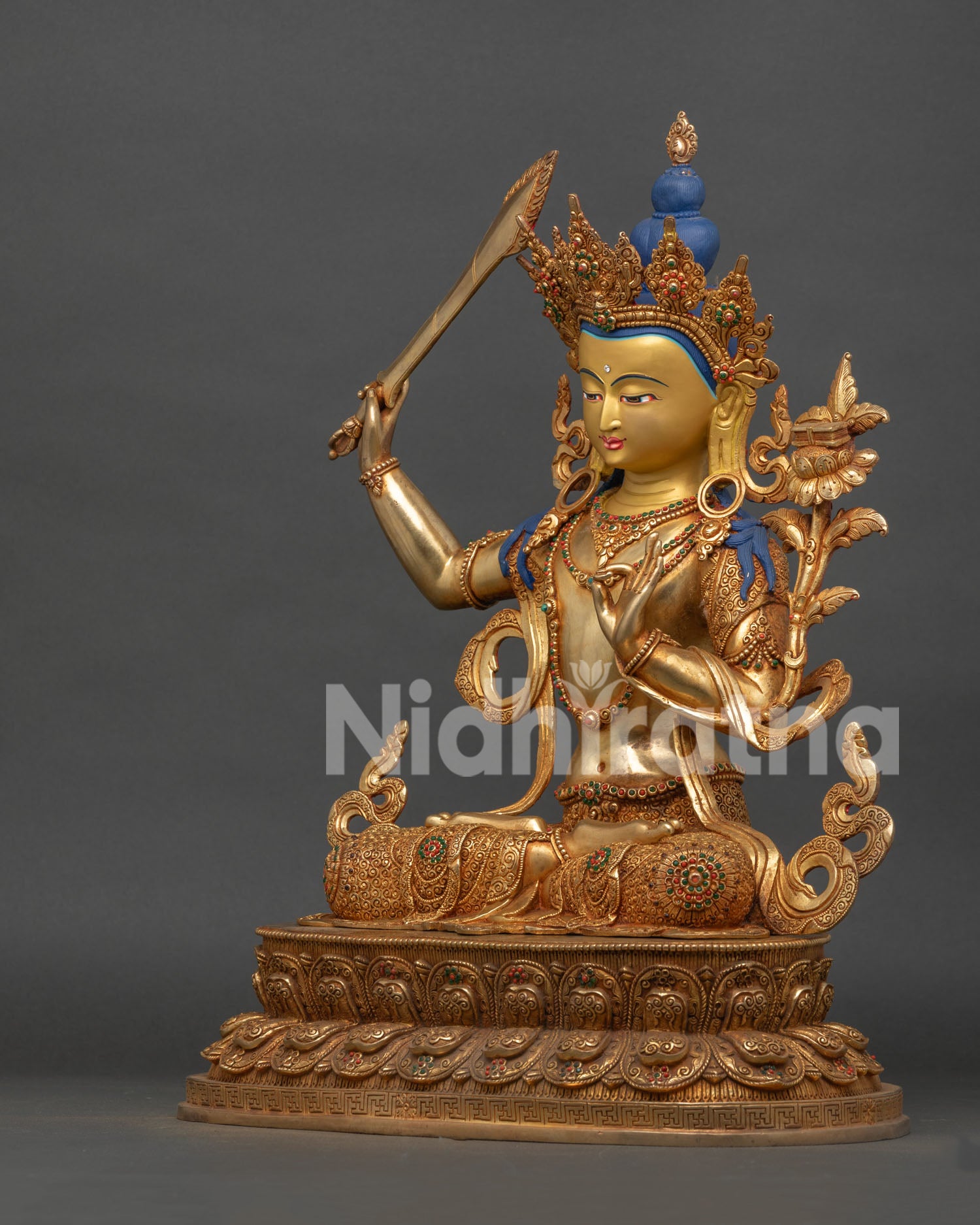 side view of gold gilded manjushri buddhist statue with intricate carvings