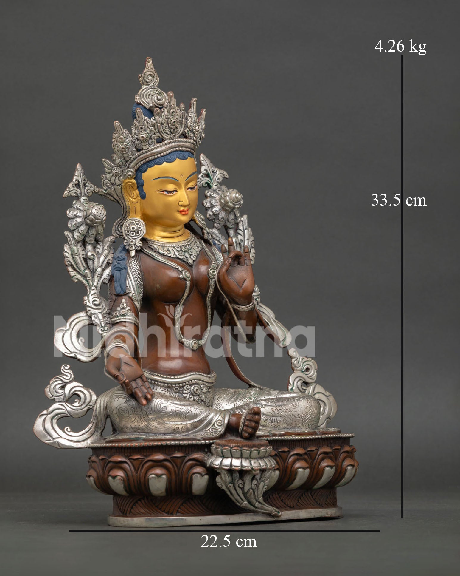 Side view of Green Tara statue, lotus posture flower symbol and traditional Himalayan metalwork