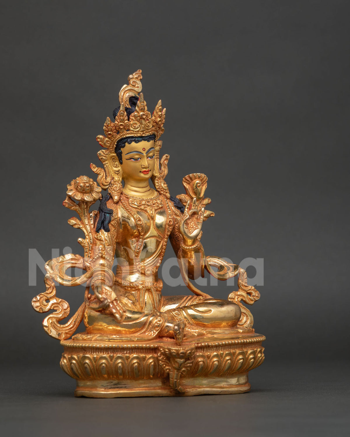 Side view of Green Tara statue showing gold fire gilded copper body and detailed lotus pedestal.