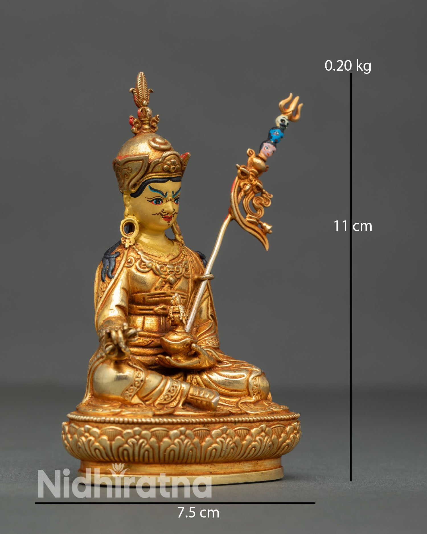 Side view of Guru Rinpoche Buddhist master statue depicting khatvanga trident staff layered robes and regal seated posture on detailed lotus seat