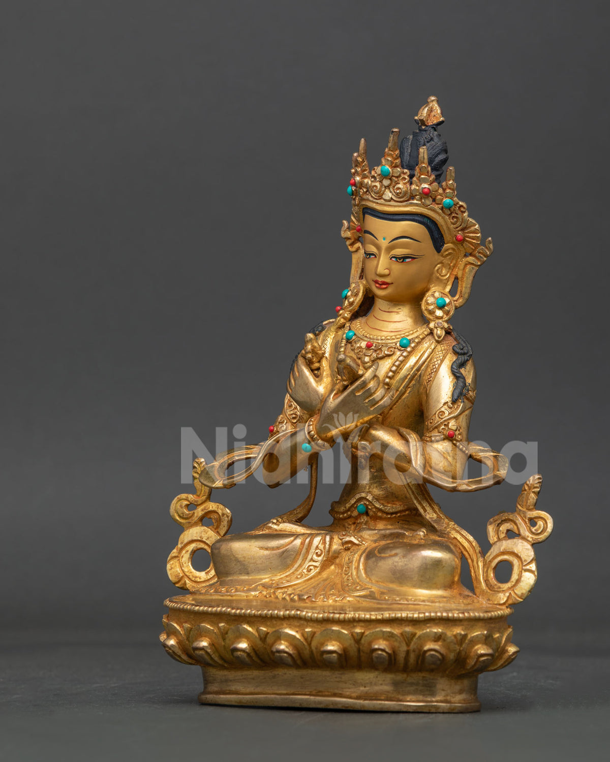 Side view of handcrafted vajradhara statue with carved lotus base and intricate nepalese metalwork.