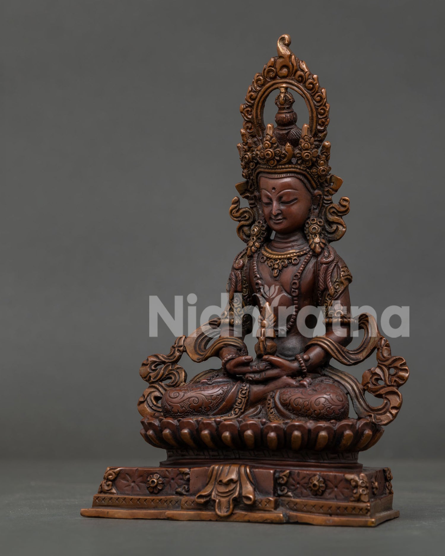 Side View of Handmade Amitayus Statue with Silk Garments and Oxidized Copper Finish.