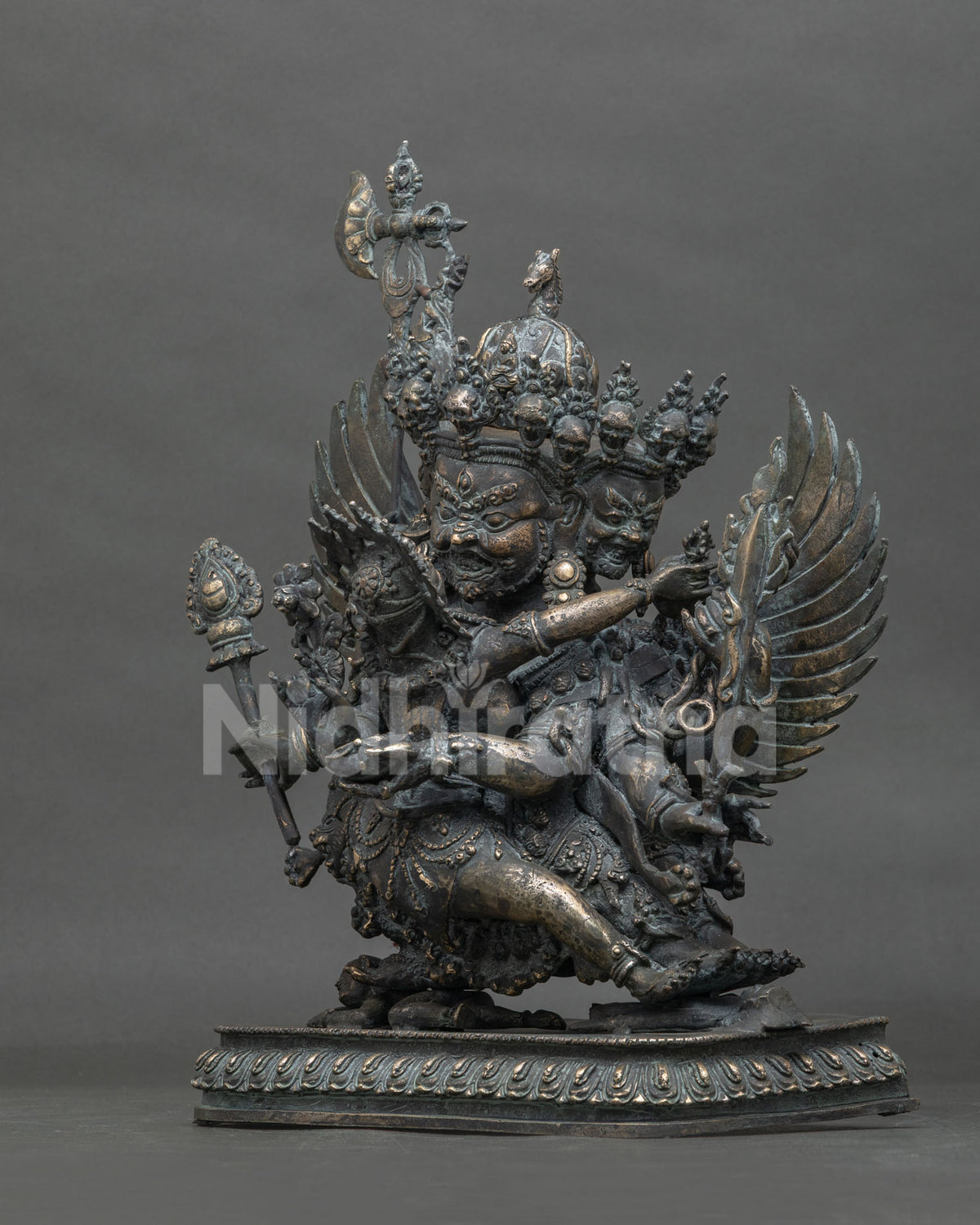 Side view of handmade Hayagriva bronze statue trampling a demon on an ornate lotus base