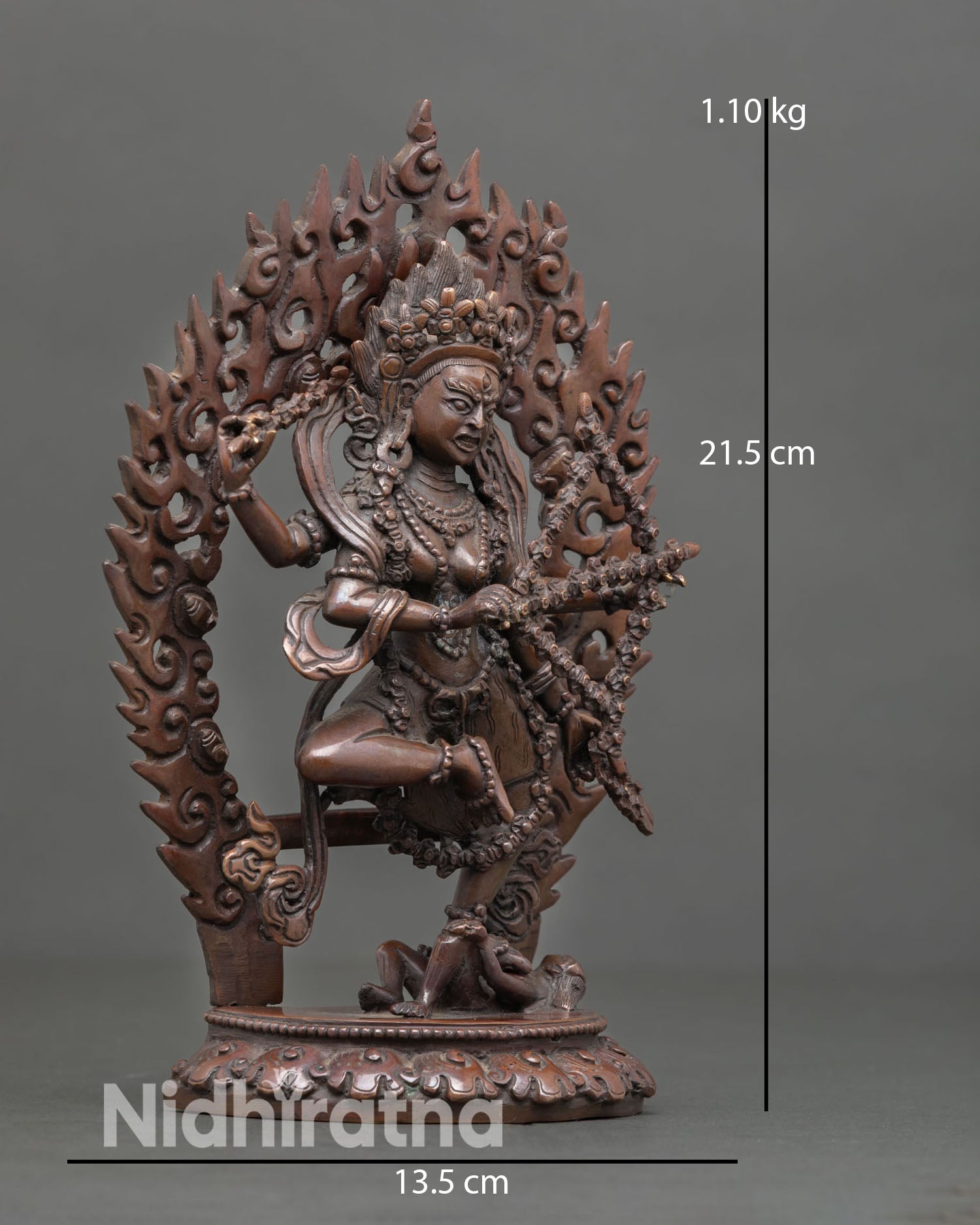 Side view of Himalayan Kurukulla sculpture in dynamic posture with flames and lotus throne in oxidized metal finish