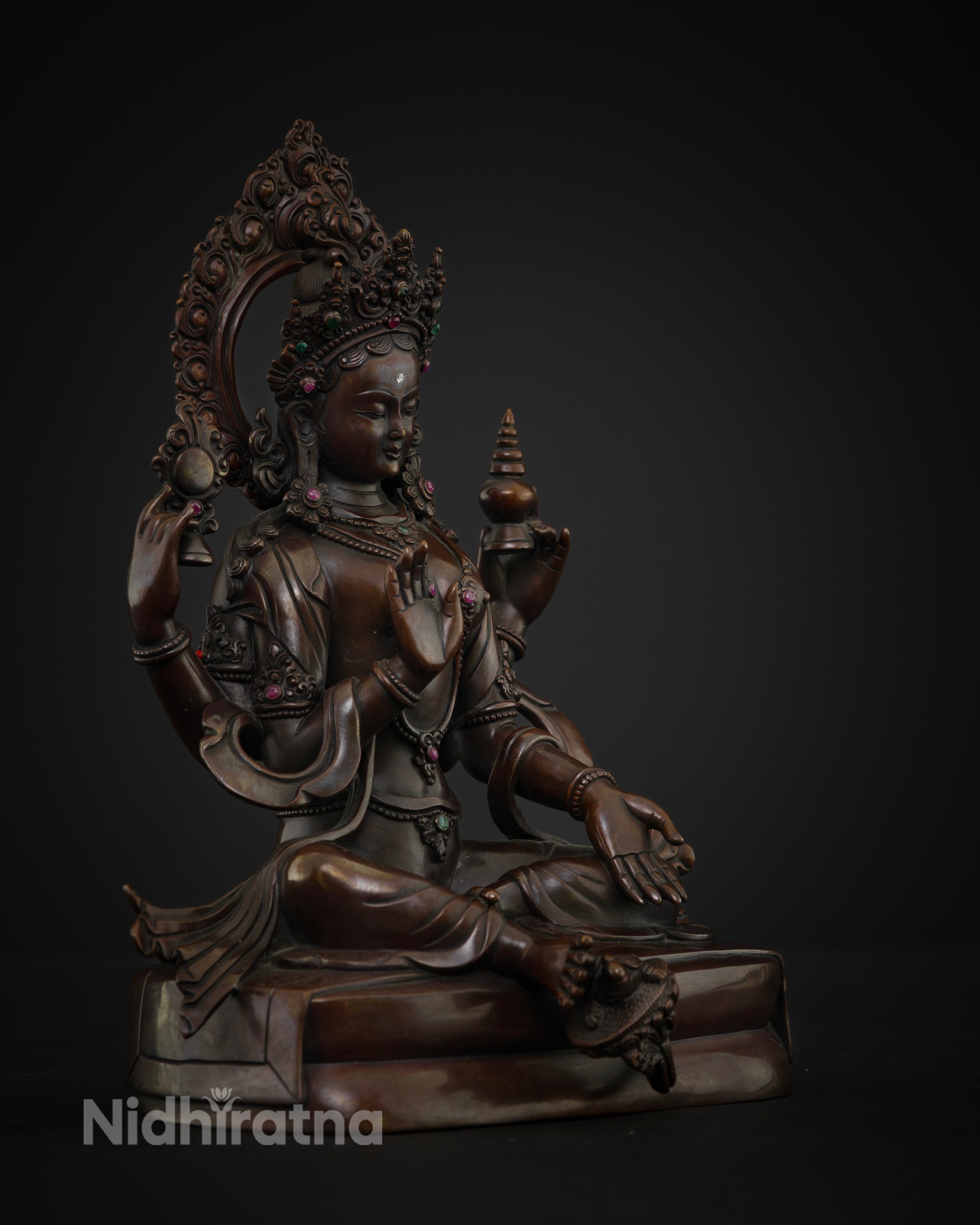 Side view of the Lakshmi statue seated on a lotus flower with four arms symbolizing Dharma, Kama, Artha, and Moksha