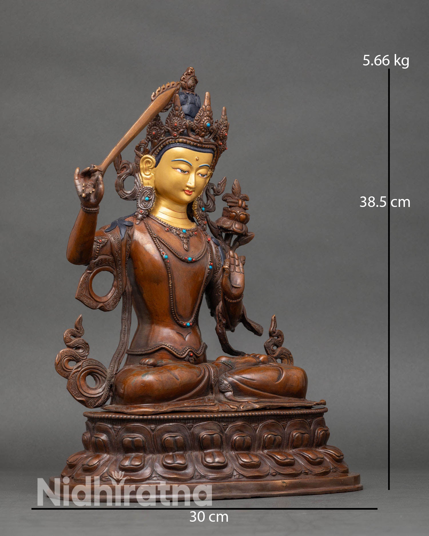 Side view of Manjushri statue holding flaming sword and lotus with Prajnaparamita scripture.