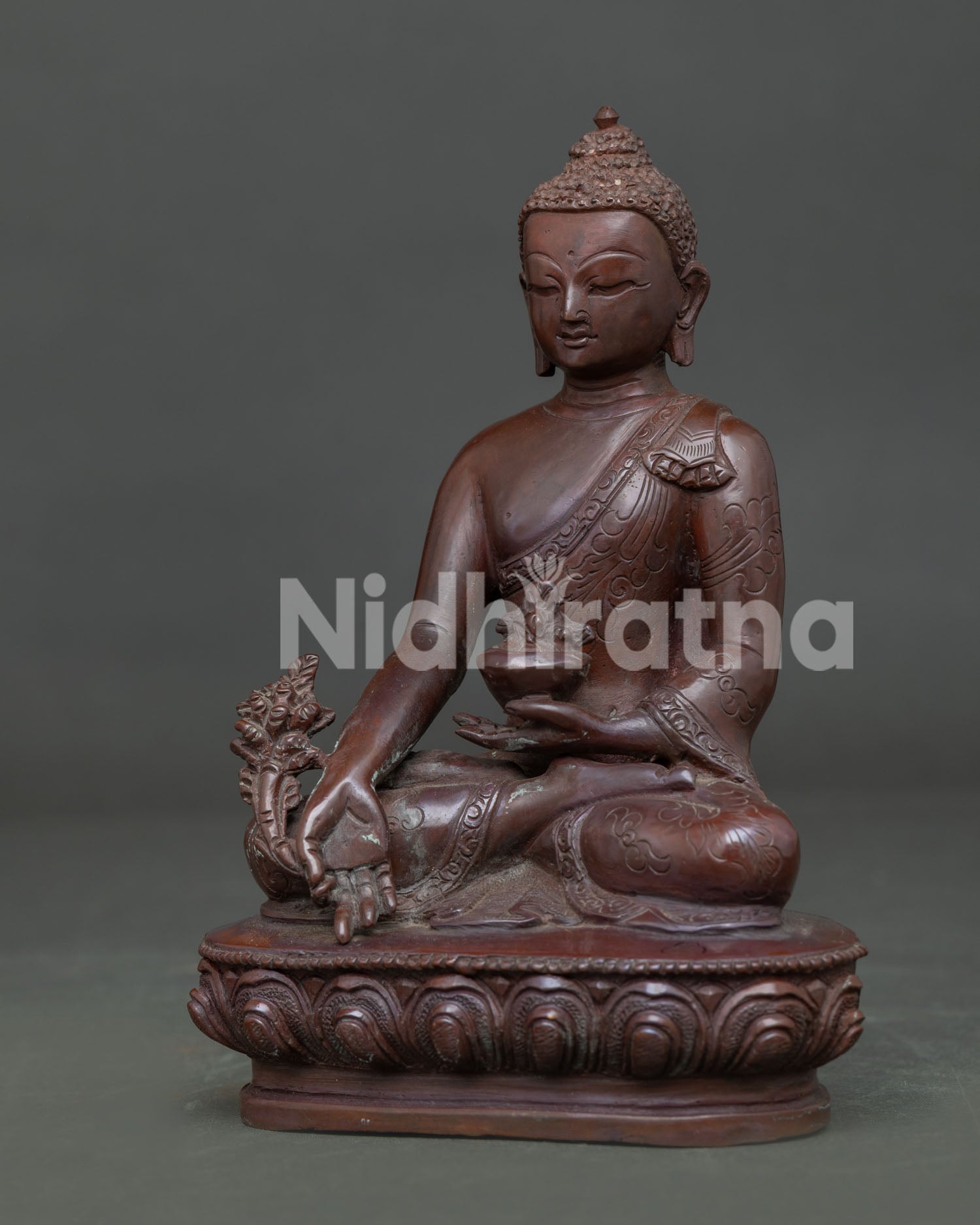 Side view of Medicine Buddha Statue with oxidized copper finish and lotus pedestal details.