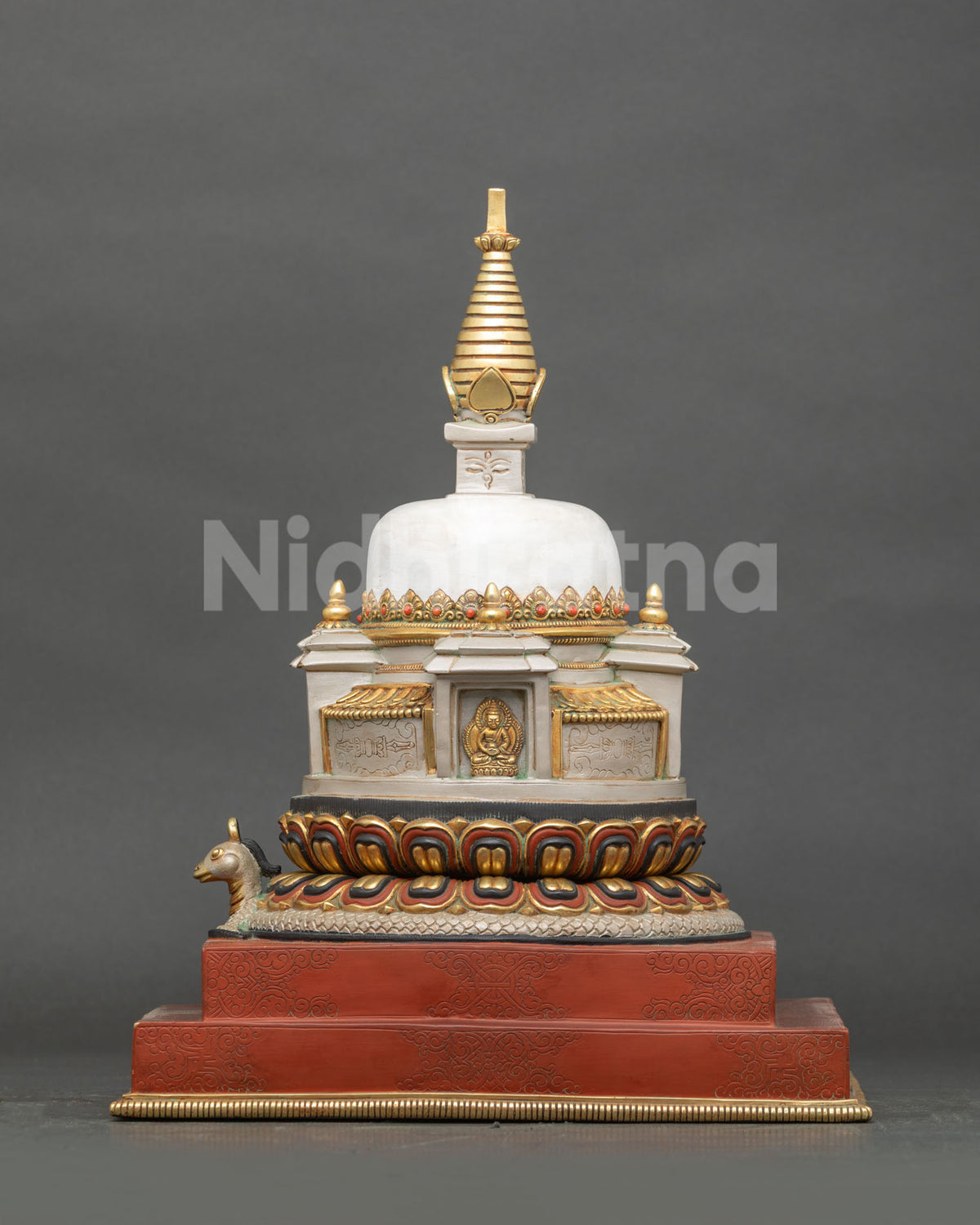 Side view of Newari handcrafted Himalayan stupa with coiled serpent on lotus base and red double pedestal