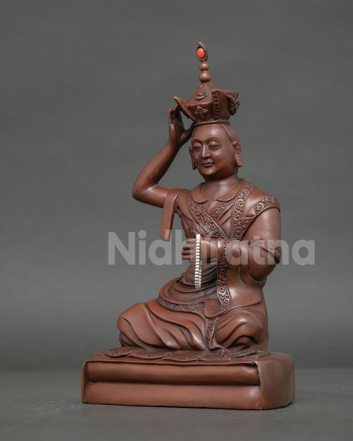 Side View of Oxidized Copper Karmapa Statue Holding Rosary Mala on Lotus Throne.