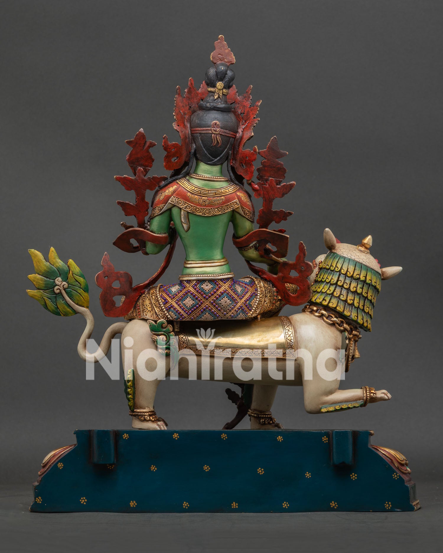 Side view of snow lion base beneath Simhanada Green Tara sculpture