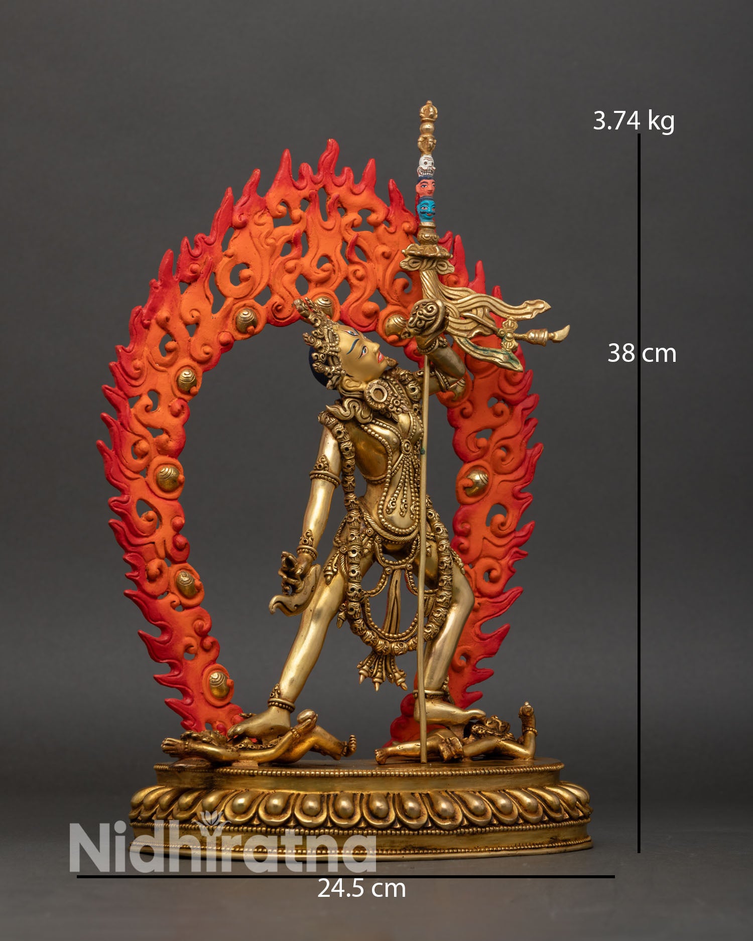 Side view Vajrayogini tantric goddess statue flowing robes flaming halo skull motifs trident shoulder dynamic posture Buddhist sculpture Nepal.