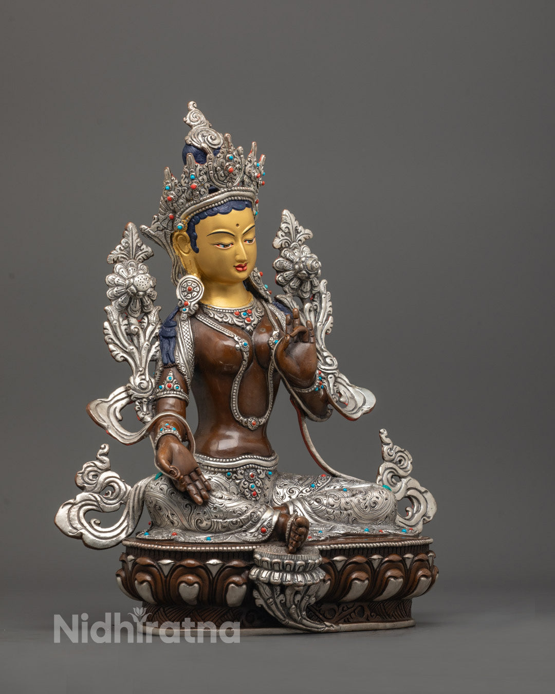 side angle of Green Tara in varada mudra with detailed robe, jewelry, and lotus seat