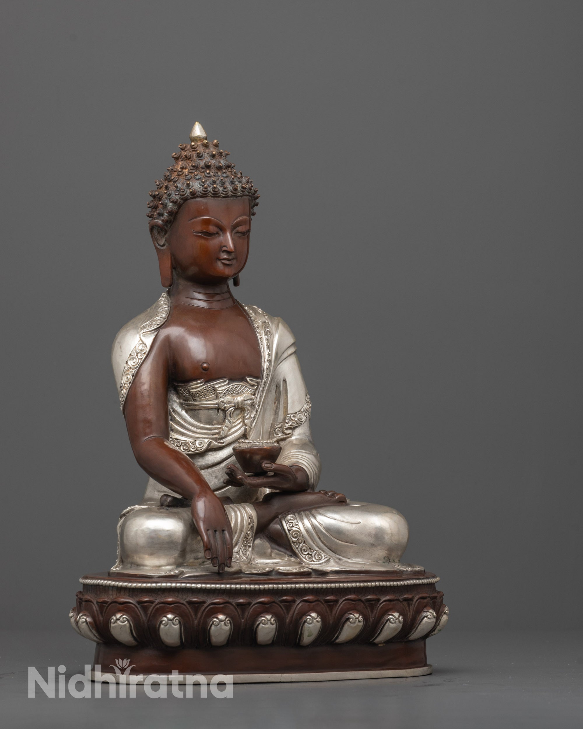 side angle of handcrafted oxidized copper face and silver-plated robe of buddha statue