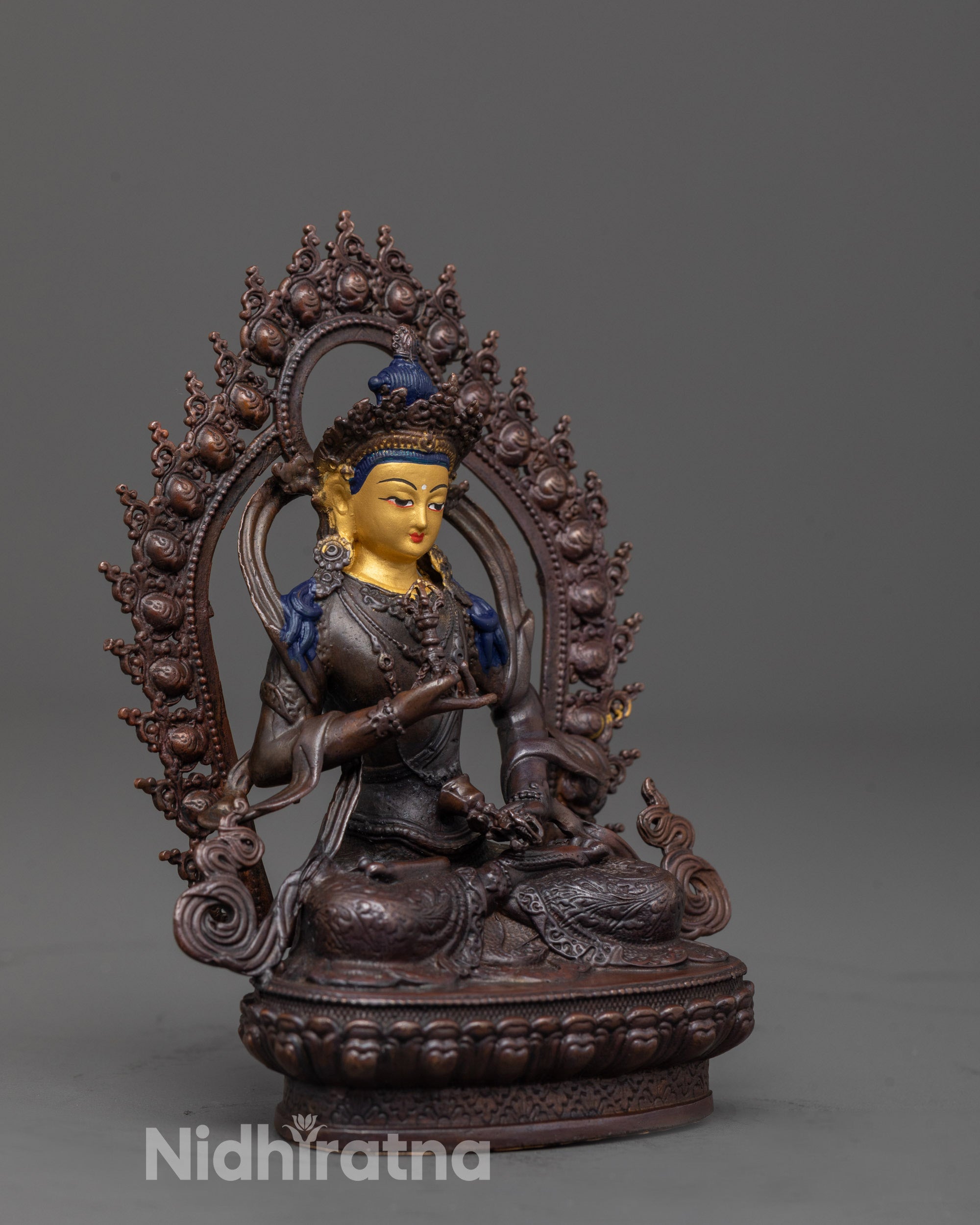 side angle of vajrasattva figurine with visible halo and vajra bell posture
