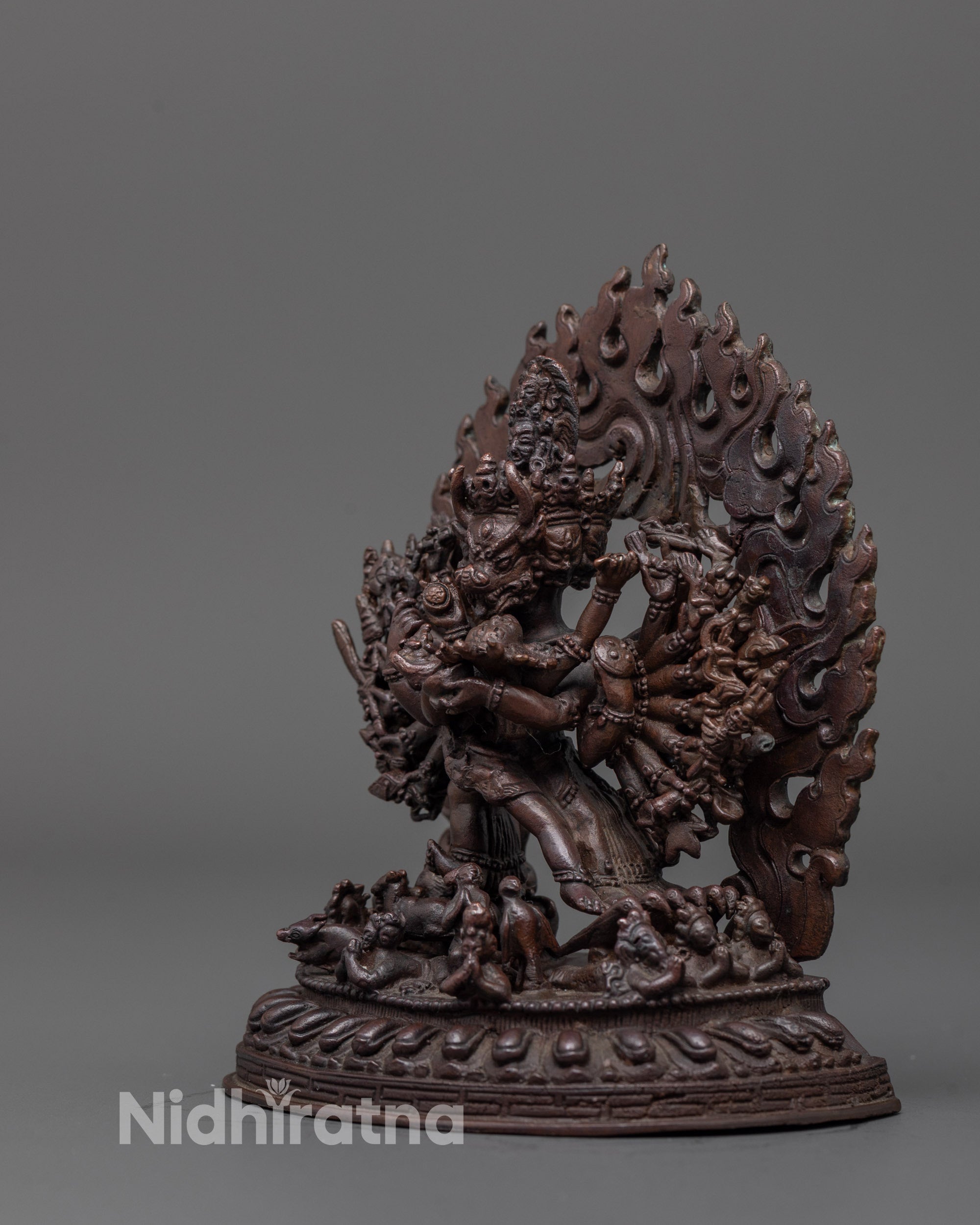 side angle of yamantaka statue with flowing robes and small deity near foot