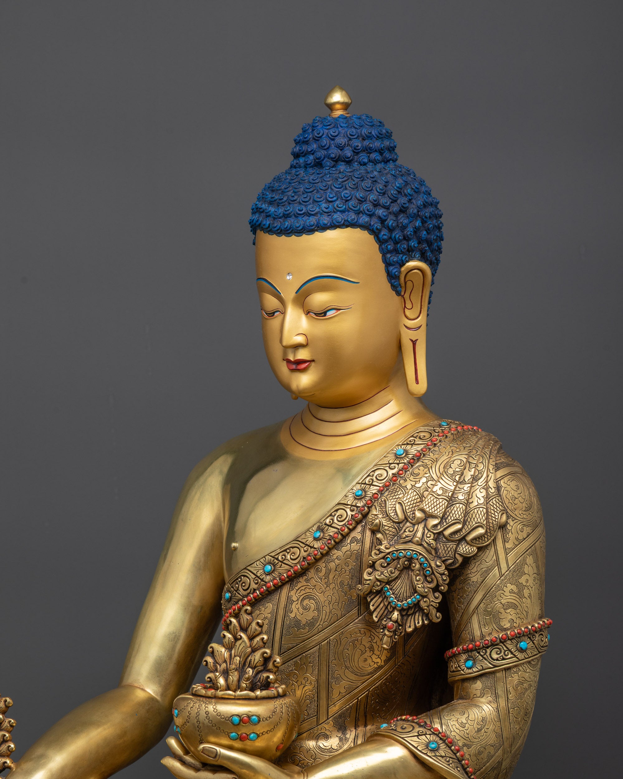 side close up face of Medicine Buddha Statue with gold halo and tranquil expression