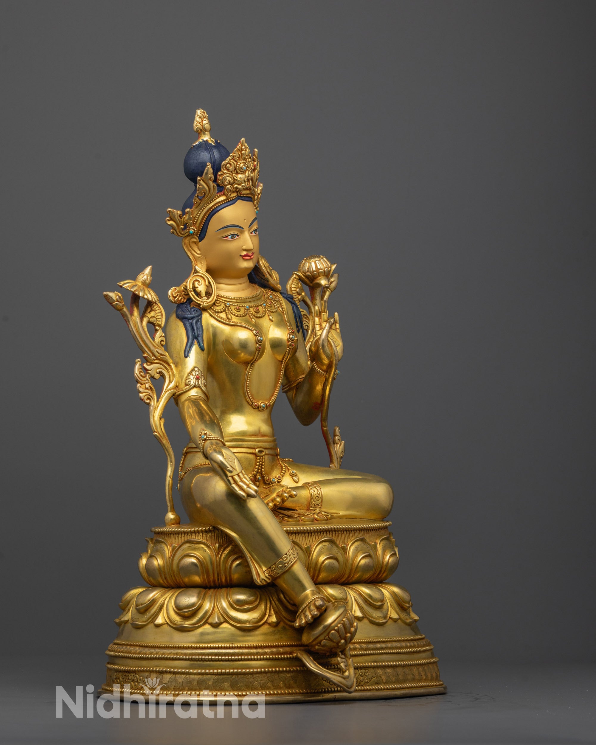 side view of handcrafted green tara idol in royal ease pose on double-layered lotus base