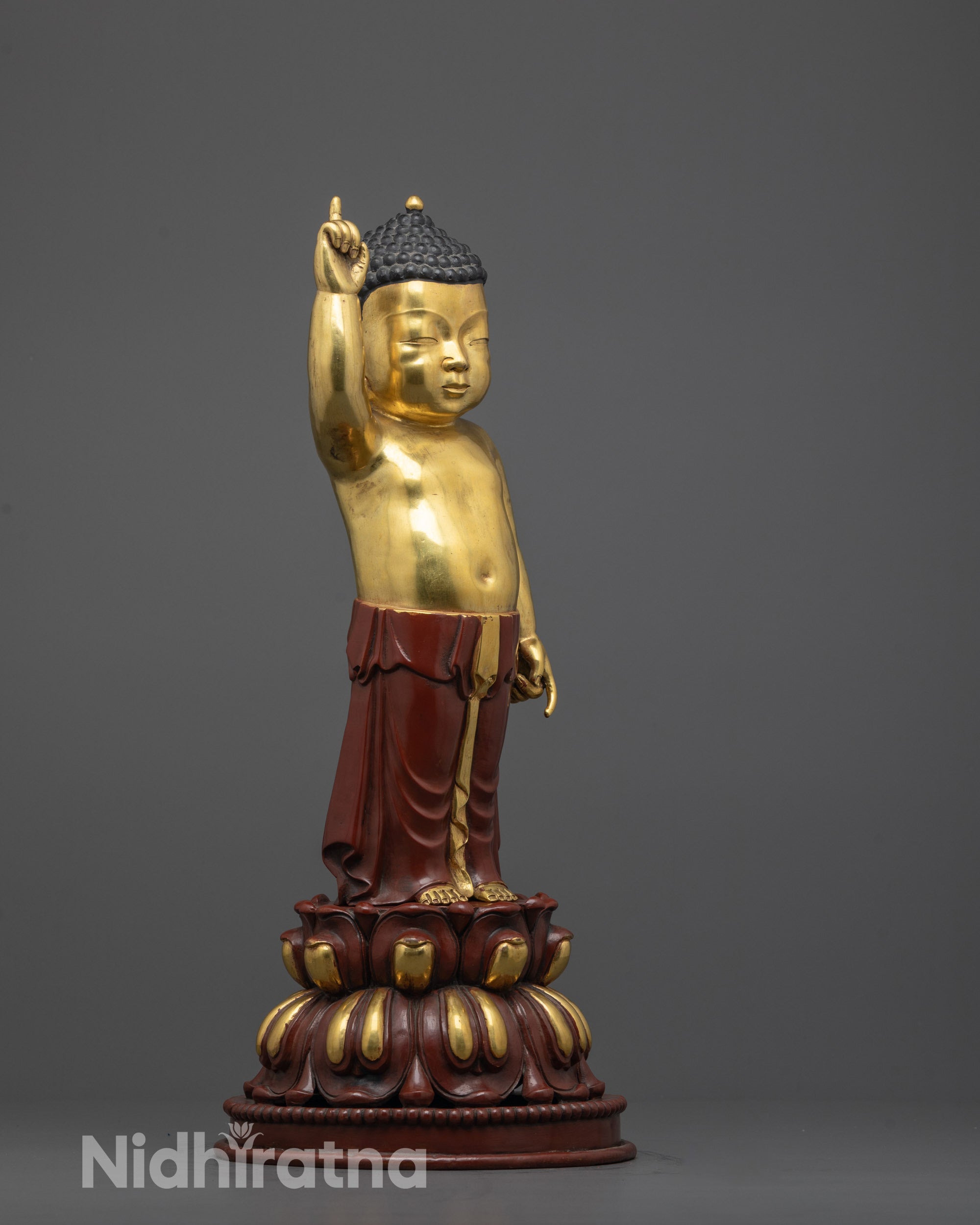 side view of little buddha sculpture showing detailed garments and lotus base
