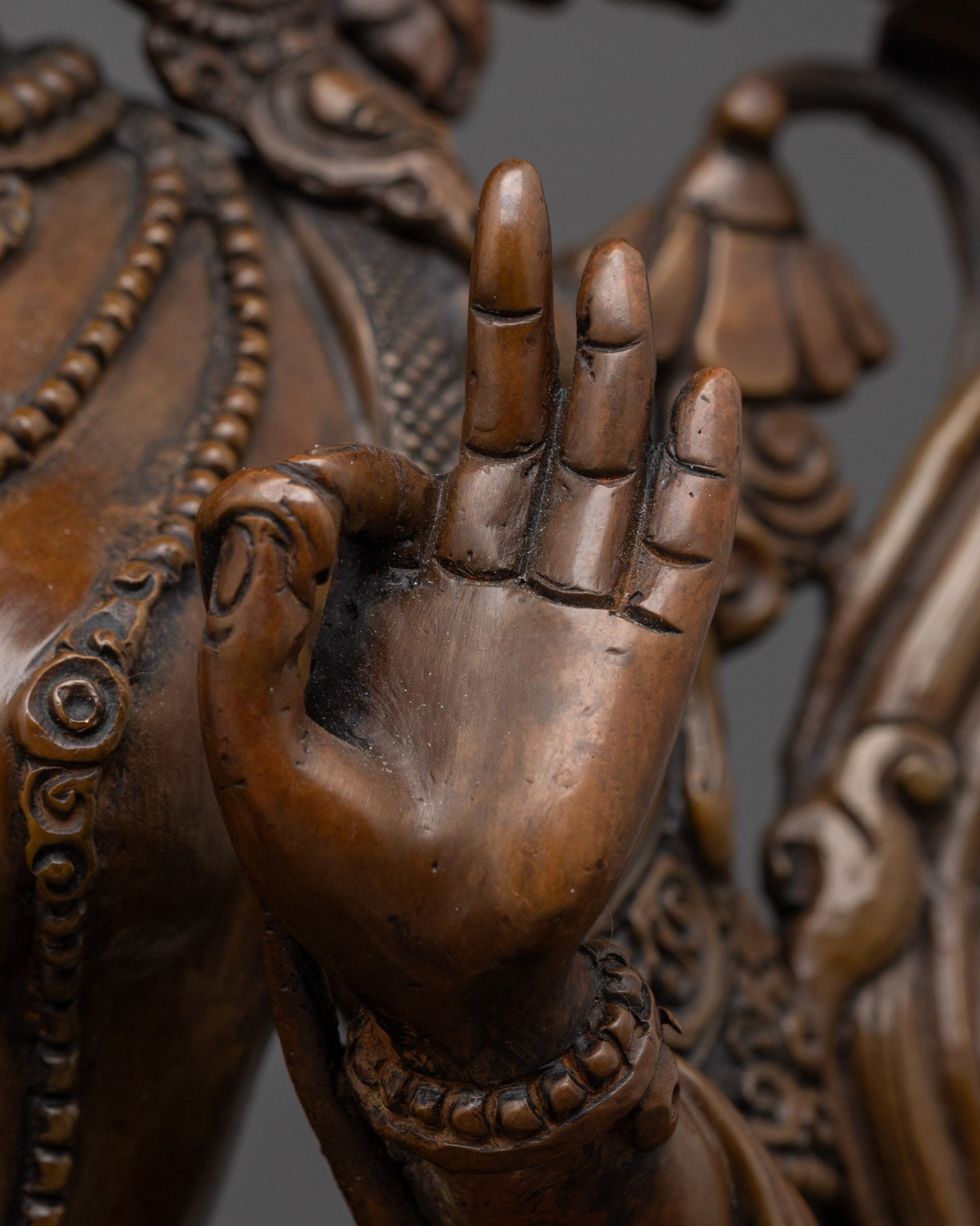 side view of white tara buddhist statue holding blue lotus with antique oxidized finish