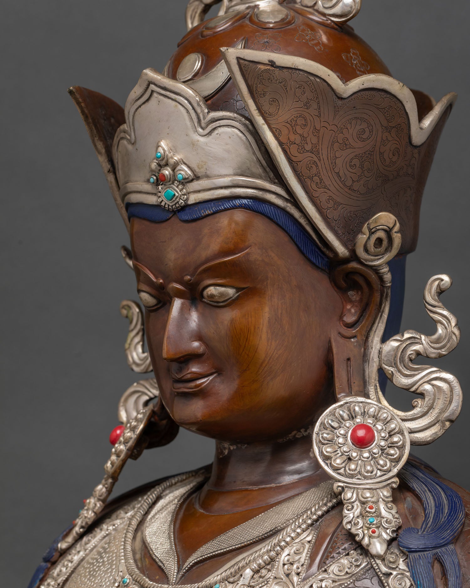 Silver repoussé detail with coral and turquoise inlay on Padmasambhava statue robes.