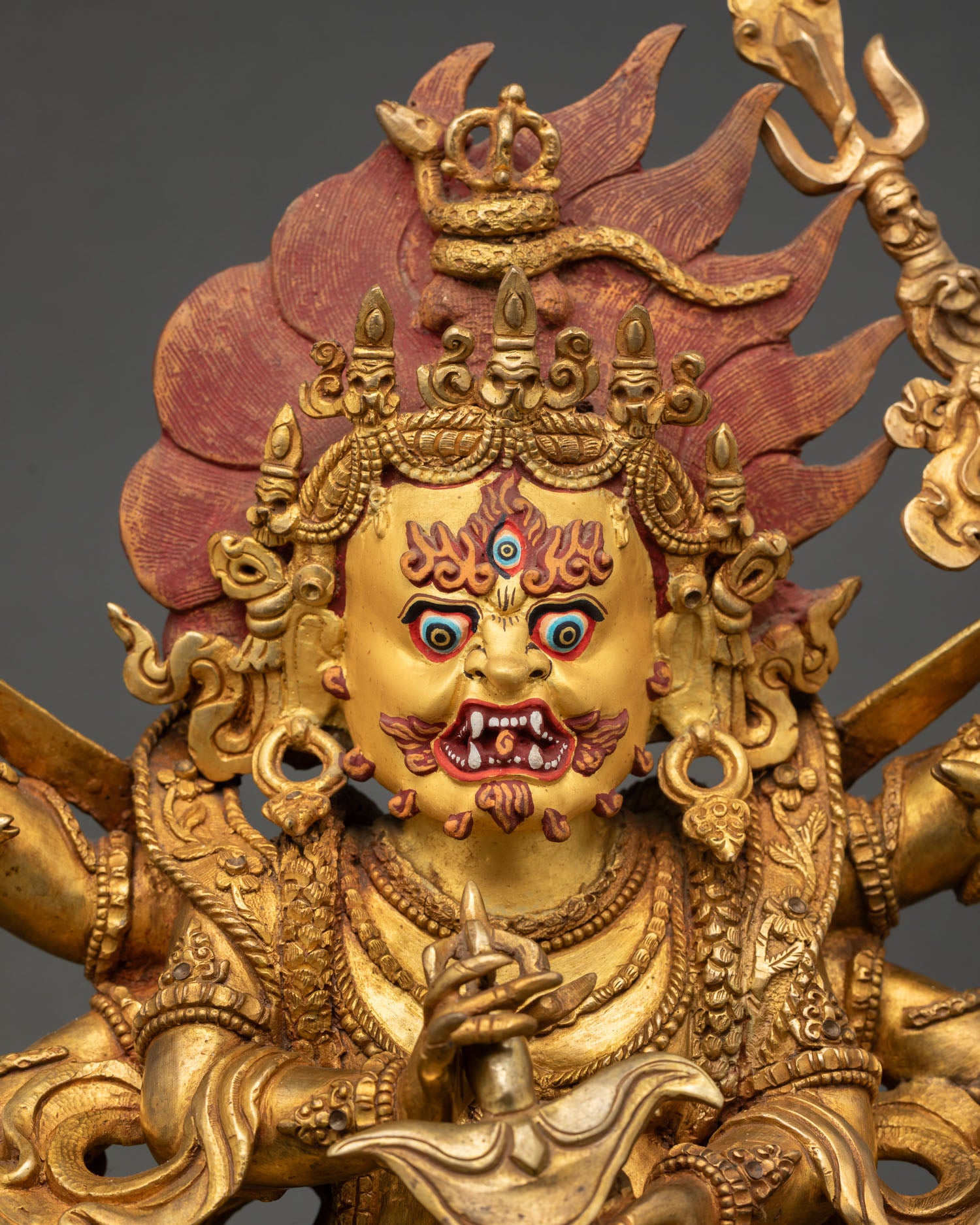 Six-Armed Mahakala Statue close up view showing wrathful face expression with three eyes and gold painted details