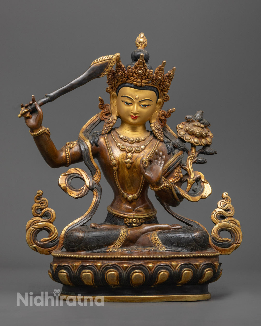 the gold-gilded face of the Oxidized Manjushri Bodhisattva Statue showcasing intricate craftsmanship by Nepalese artisans