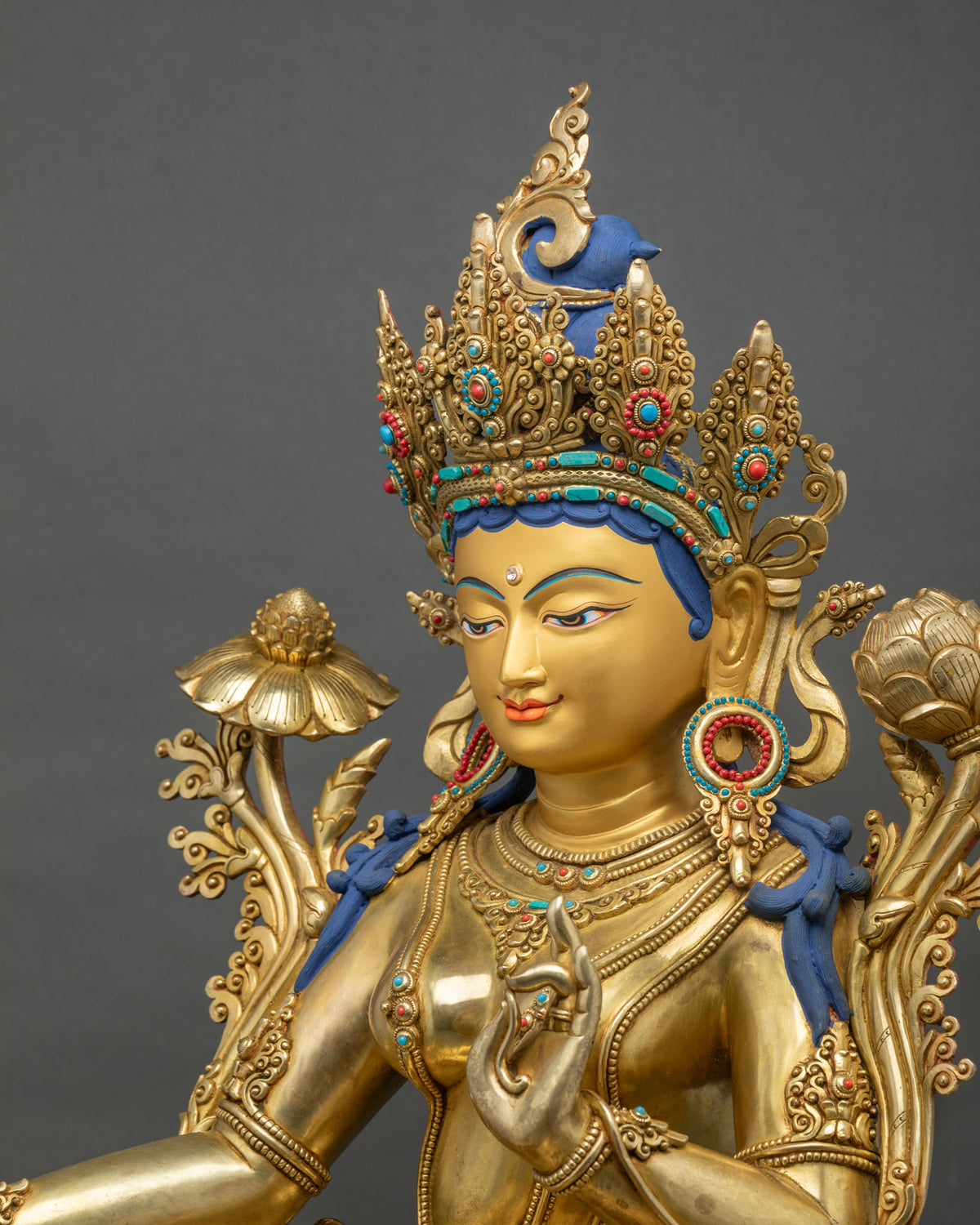 Three-quarter close-up of Green Tara statue showing Abhaya Mudra, jeweled crown and utpala lotus
